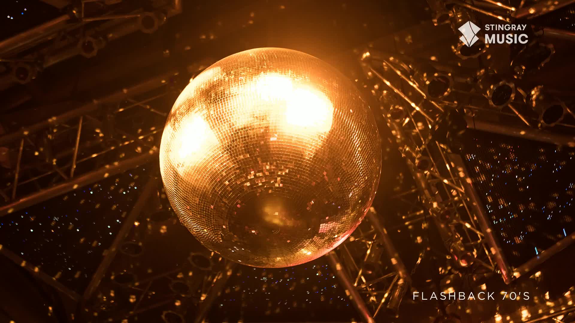 The disco ball hangs, reflecting warm light across the room. Tiny, shimmering specks dance from the surface, a 70's flashback in Canada.
