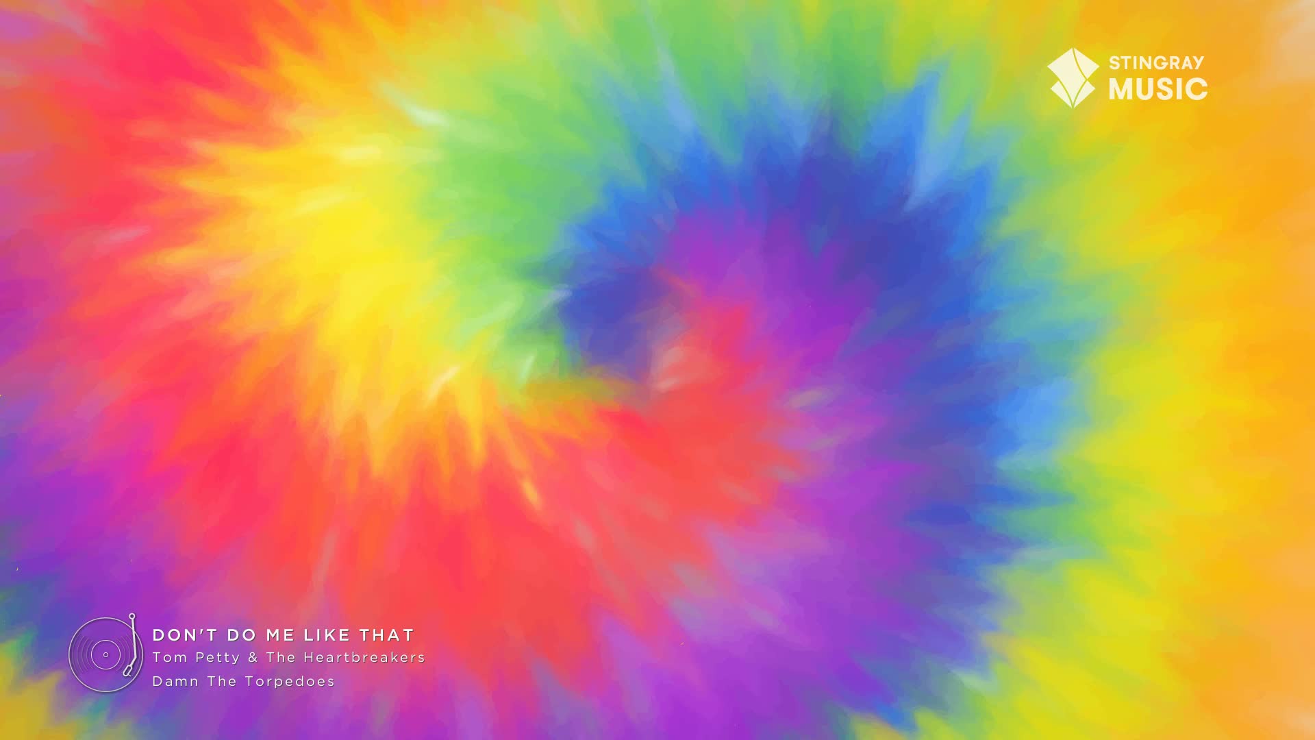 A swirling tie-dye pattern of vibrant colors dominates the view. The Stingray Music logo and a Tom Petty song title appear in the corner, immediately giving off a 70s vibe.
