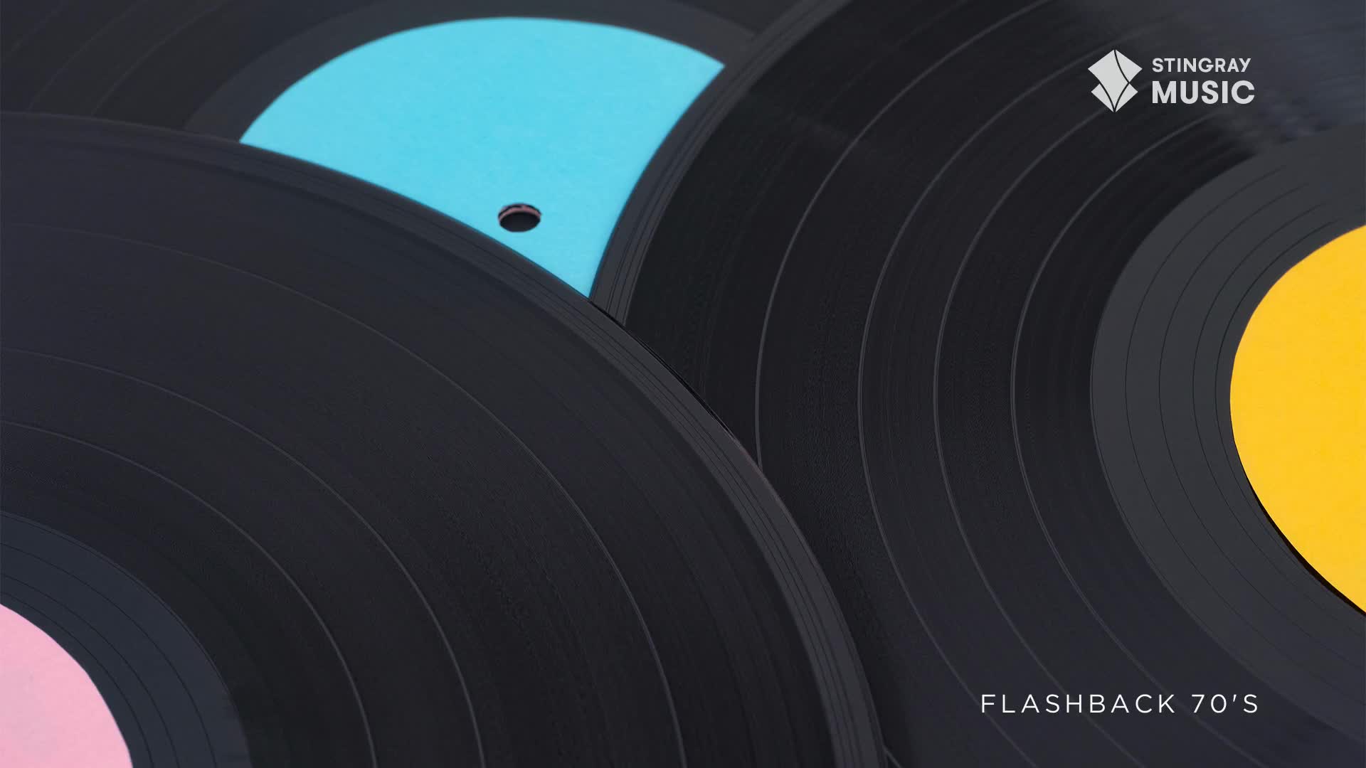 Black vinyl records overlap, their colorful labels peeking out from beneath. The Stingray Flashback 70's logo sits in the corner, a reminder of the music to come.
