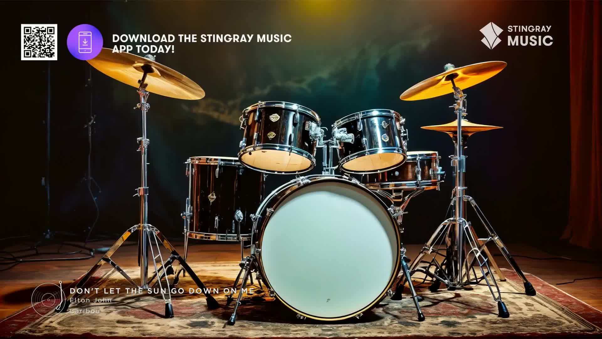 A drum kit, gleaming under the lights, sits center stage. The Stingray Music logo is visible, and the song "Don't Let the Sun Go Down on Me" by Elton John is featured.
