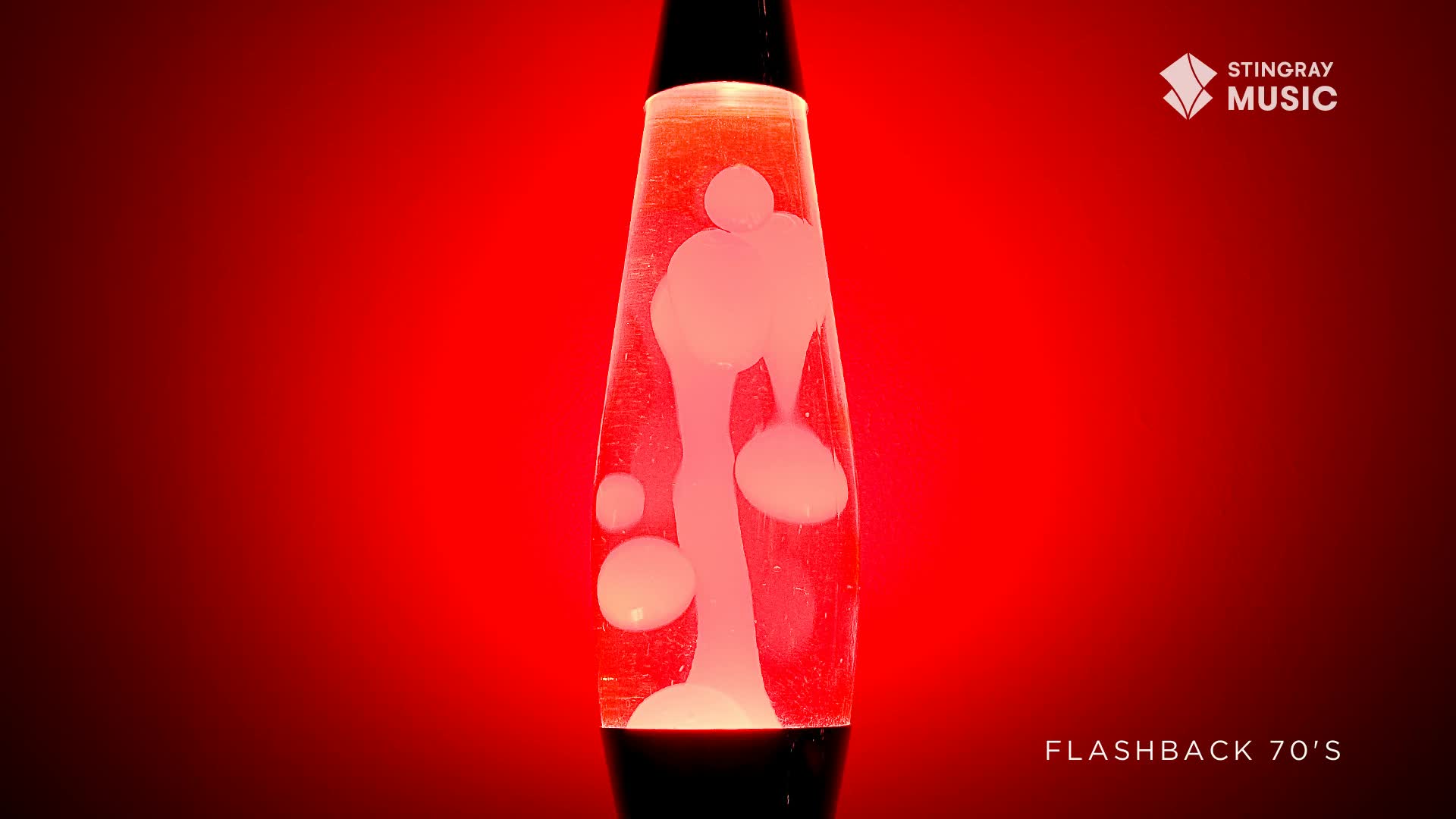 A retro lava lamp, bathed in a red glow, is slowly shifting.  Inside, the white blobs are rising, then melting and reforming, a perfect vibe for a Stingray Flashback from the 70s in Canada.
