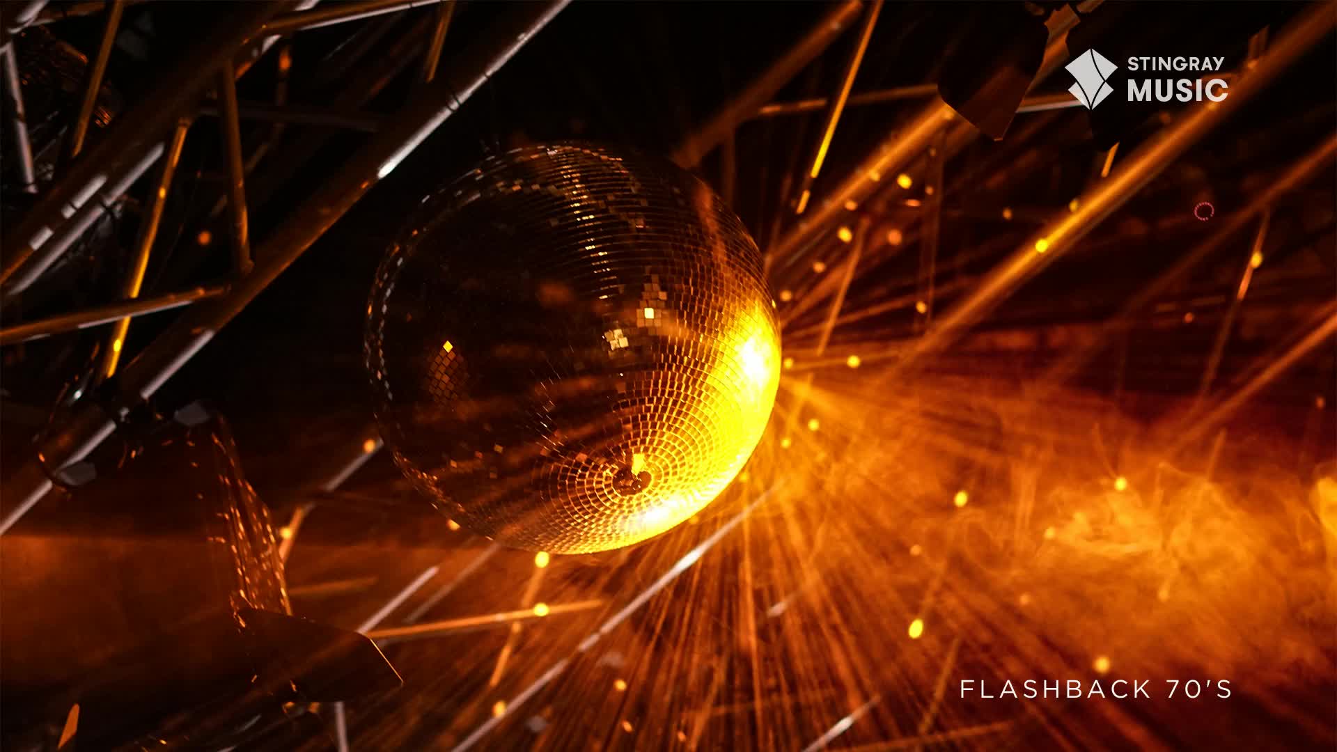 A disco ball, lit up, is the focal point, sending out beams of warm light across the space. The Stingray Flashback 70's logo confirms this is a retro dance party in Canada.
