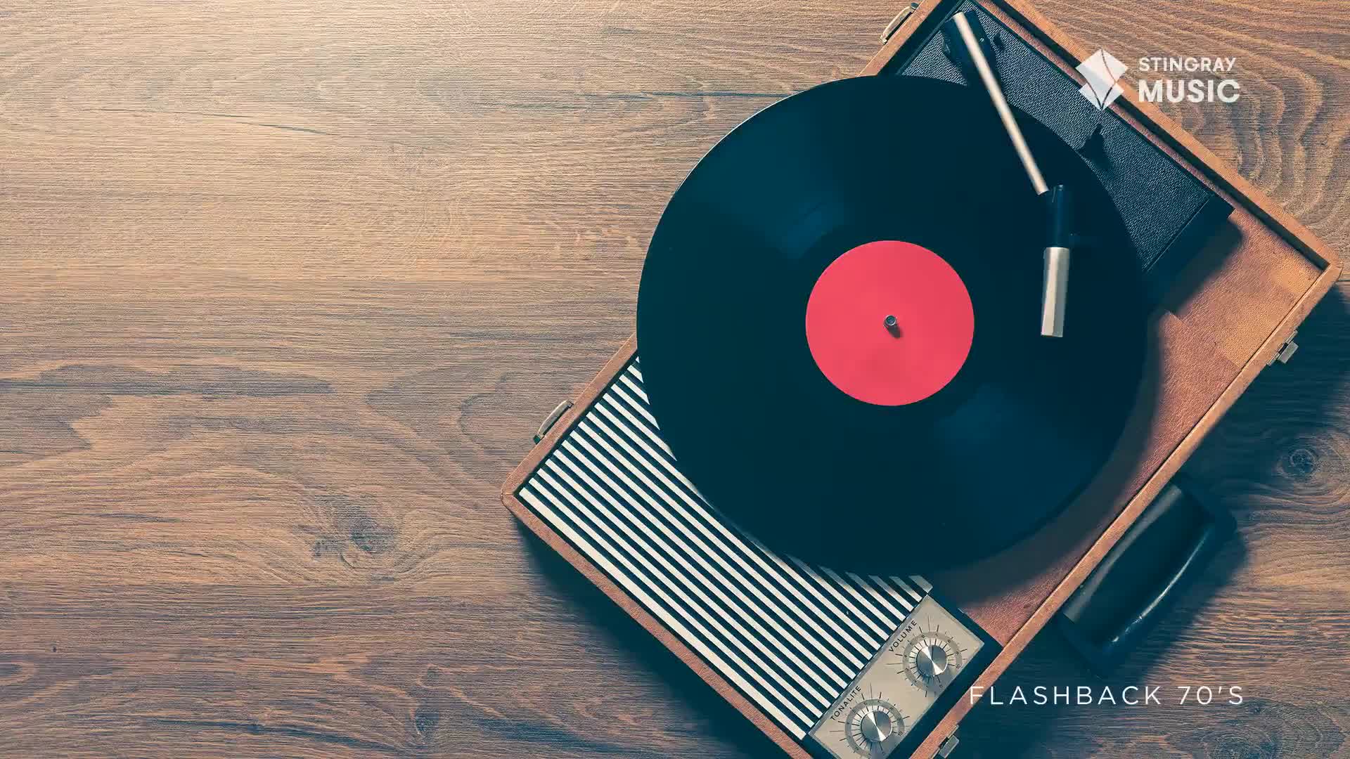 A black vinyl record spins on a portable turntable, its red center a focal point. The wooden surface beneath the record player is smooth and worn, a perfect setting for a Stingray Flashback from the 70s.
A black vinyl record spins on a portable turntable, its red center a focal point. The wooden surface beneath the record player is smooth and worn, a perfect setting for a Stingray Flashback from the 70s.
