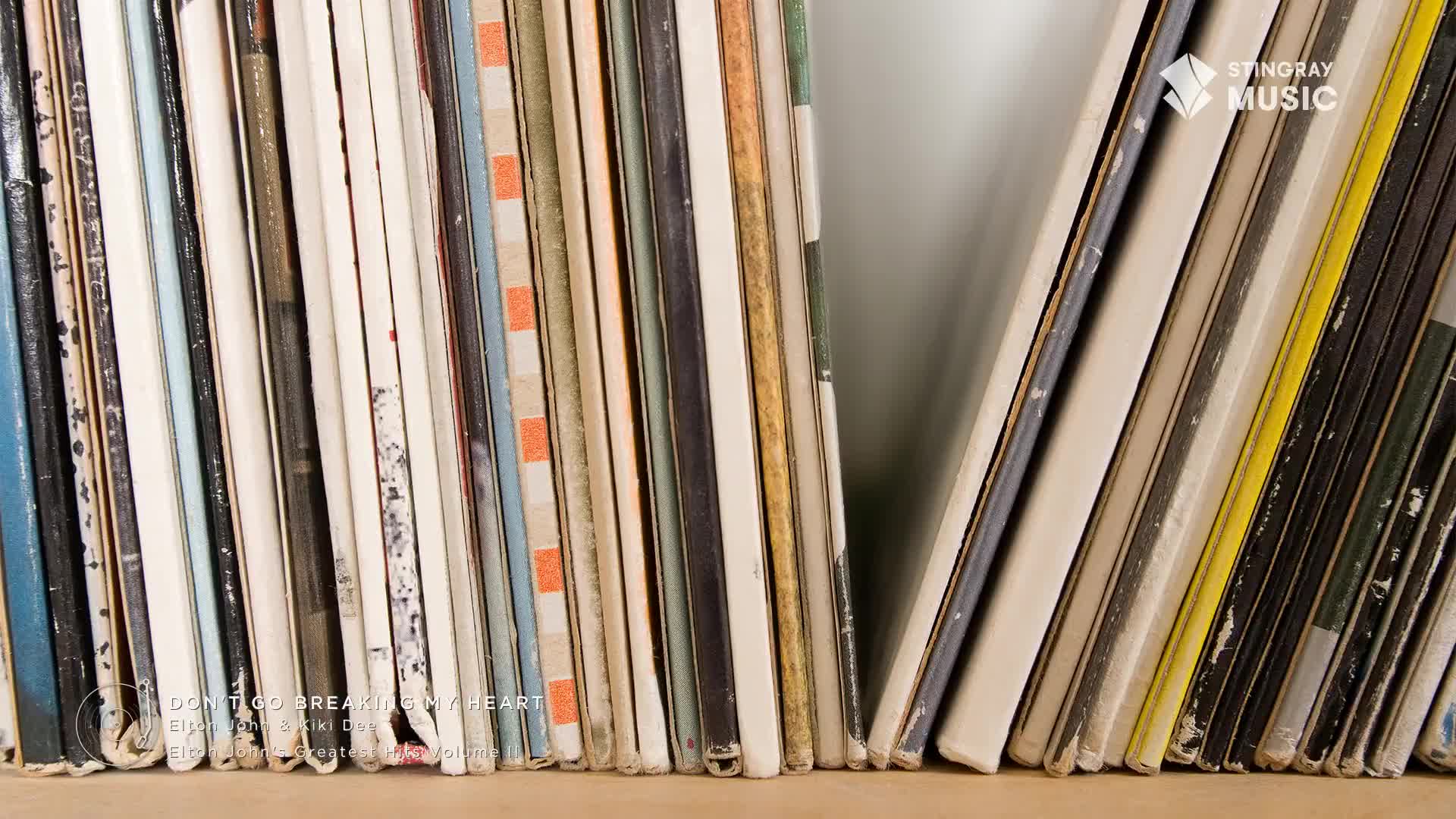 A wall of vinyl records stands before me, their spines a mix of faded colors and textures. Some sleeves show the wear of many plays, a testament to their 70s Canadian roots.