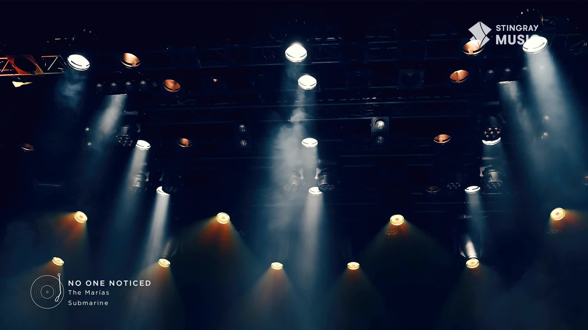 Bright spotlights cut through the haze, illuminating the stage for the Stingray Hit List performance. The lights are focused on the stage, ready for the show in Canada.
