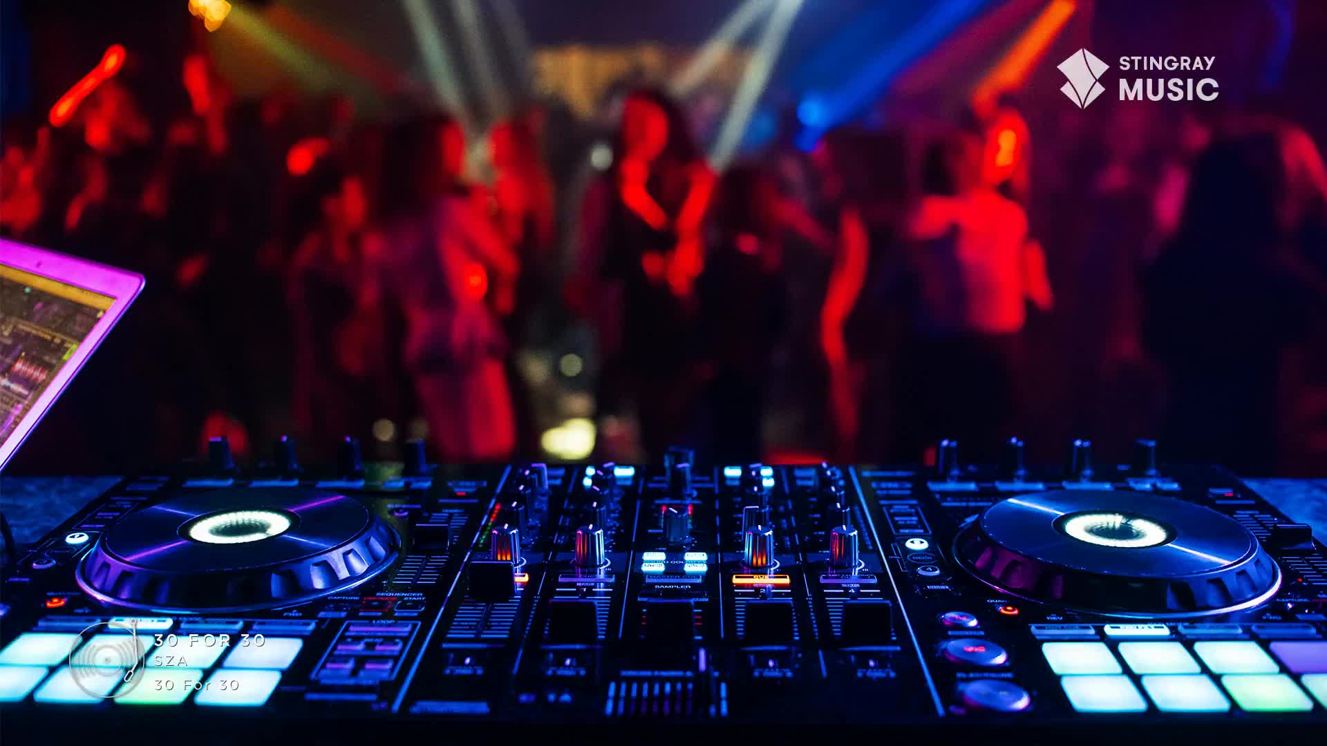 A DJ setup, bathed in blue and purple light, is the focal point. In the background, a crowd dances under red and yellow spotlights, likely enjoying the Stingray Hit List.
