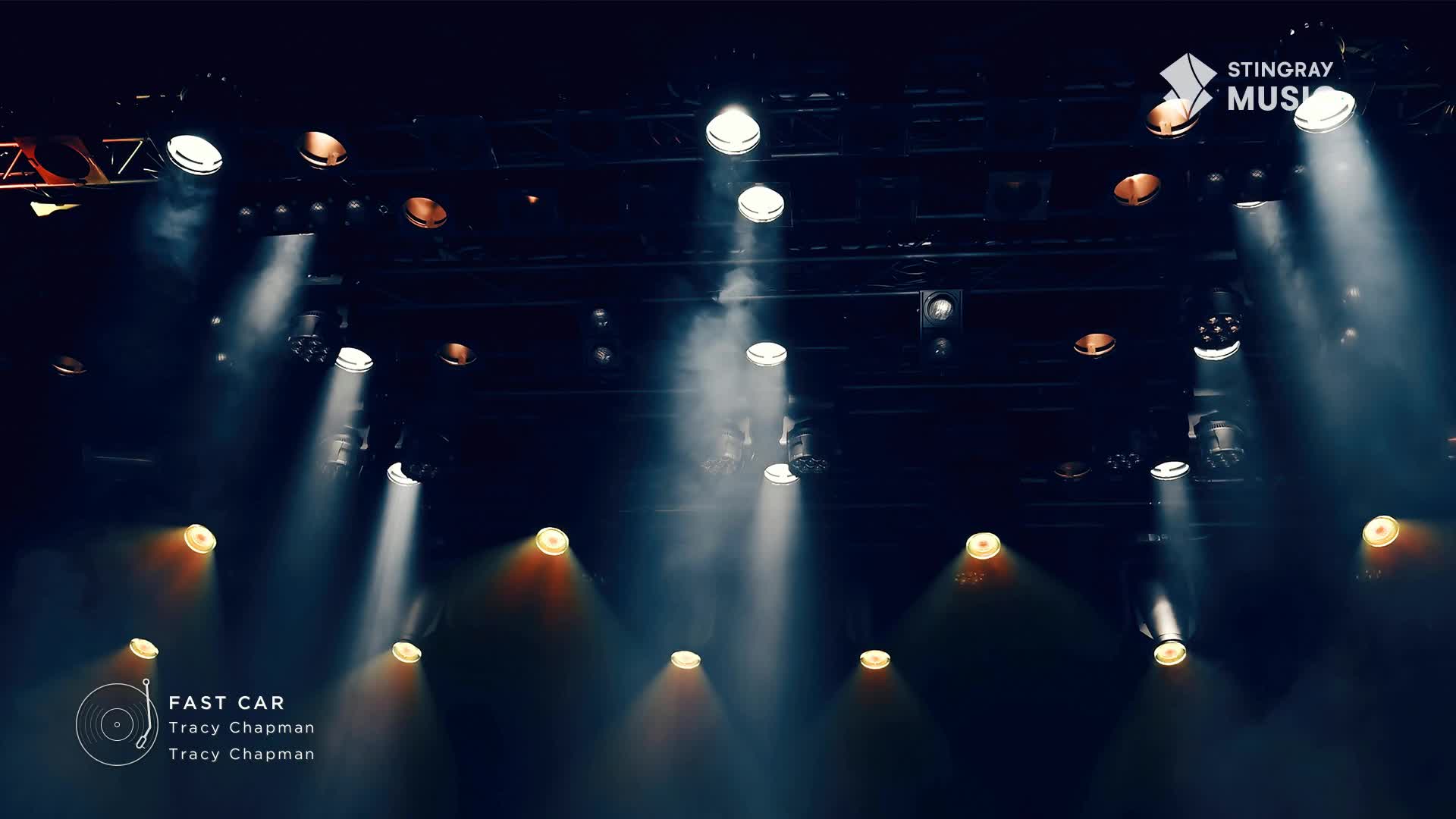 Bright spotlights cut through the haze, illuminating the stage. The Stingray Hit List logo sits in the corner, and the song "Fast Car" by Tracy Chapman is about to begin.
