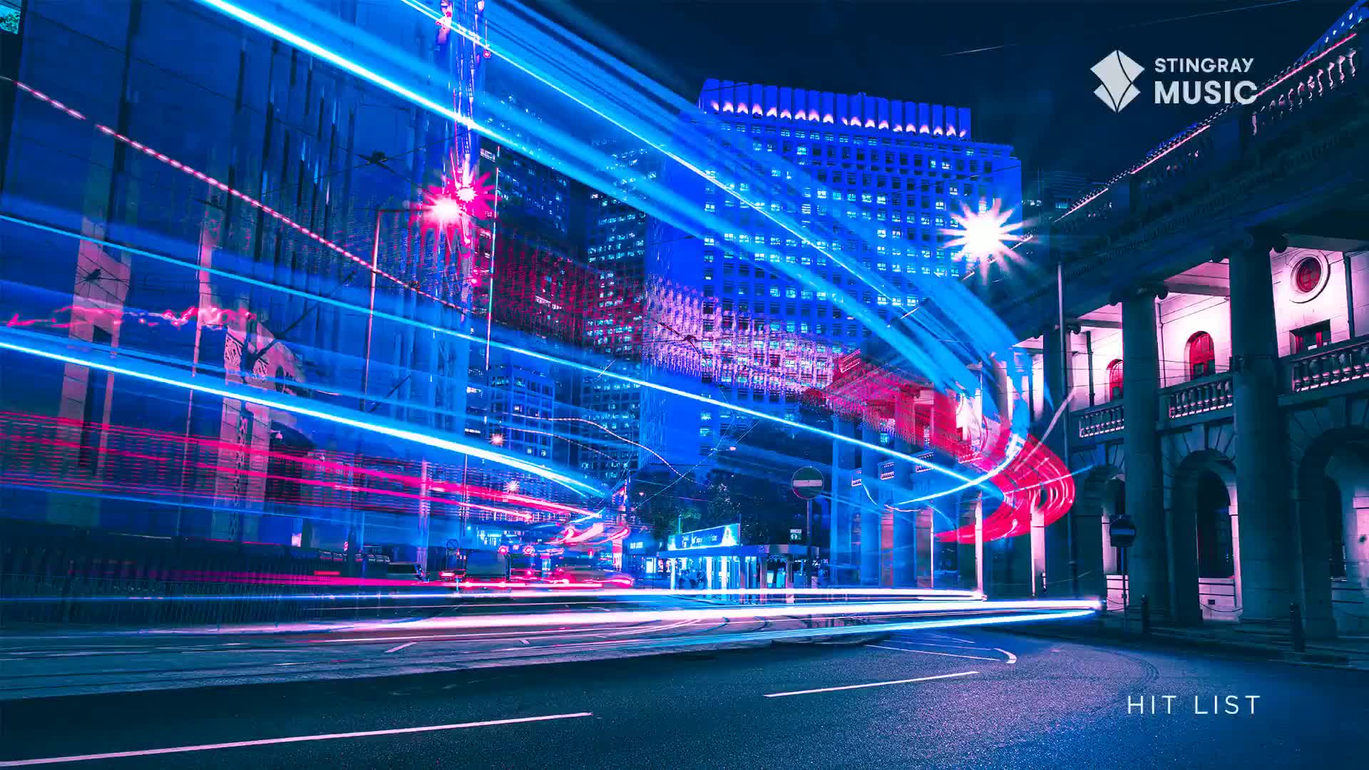 Streaks of light, a mix of blue and pink, arc across the city streets. The Stingray Hit List is playing on the big screen, and the buildings are bathed in neon glow.
