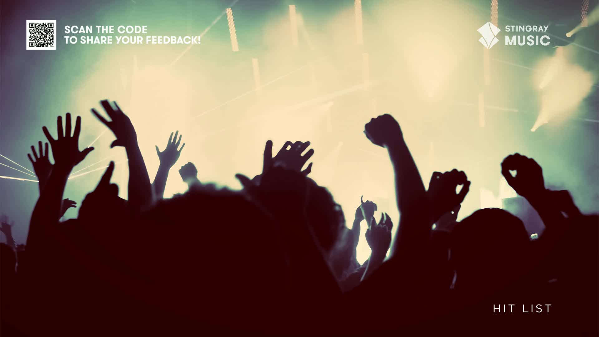 Arms are raised in the air, silhouetted against the stage lights. The crowd is clearly enjoying the music, part of the Stingray Hit List experience in Canada.
