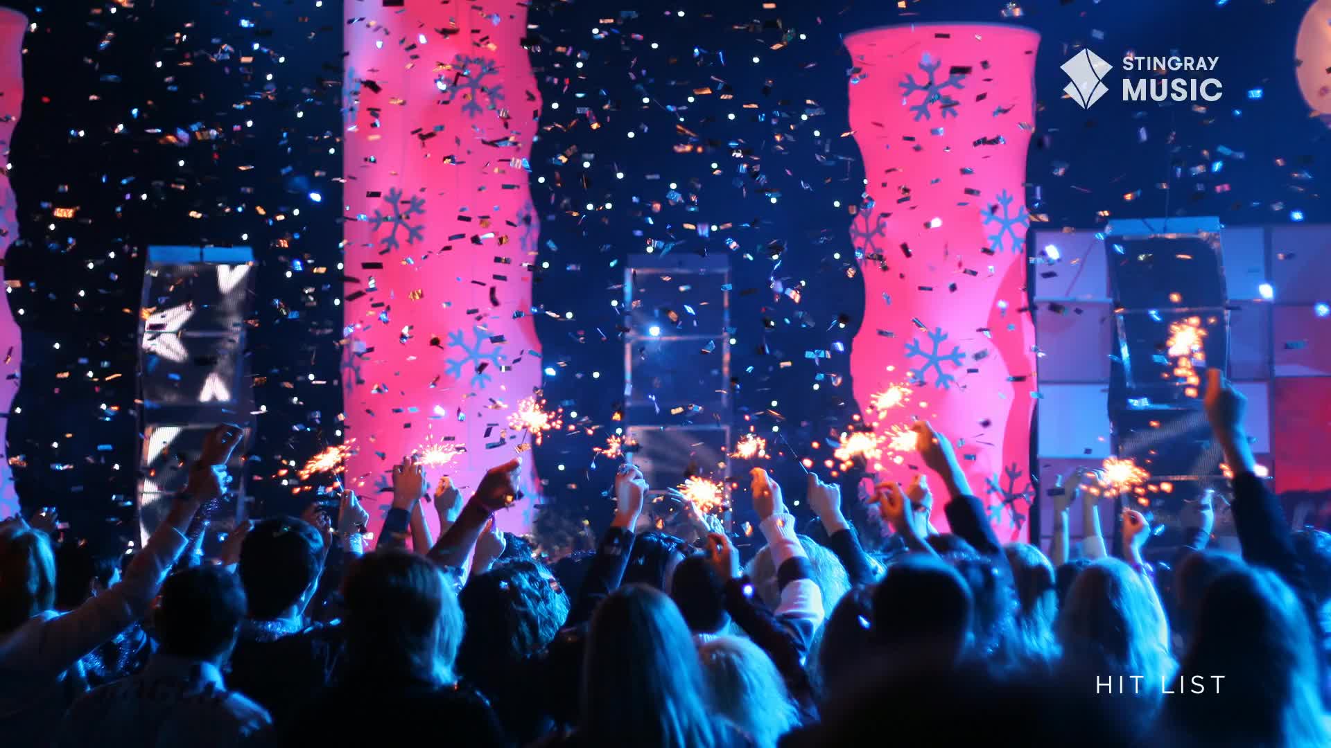 Confetti rains down as the crowd, lit by pink and blue lights, holds up sparklers. The Stingray Hit List stage is alive with energy.
