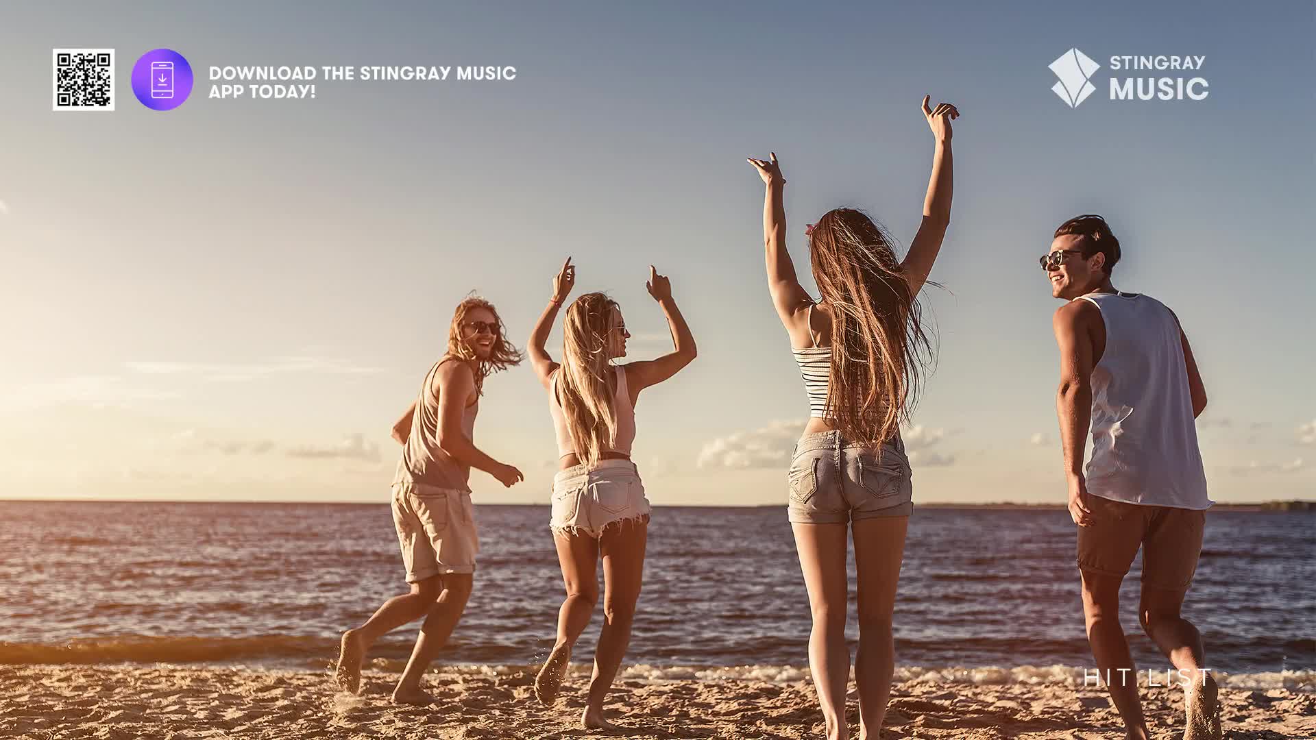 Four friends, arms raised and laughing, are dancing on the beach as the sun sets. The Stingray Hit List is probably playing, and they're having a blast.
