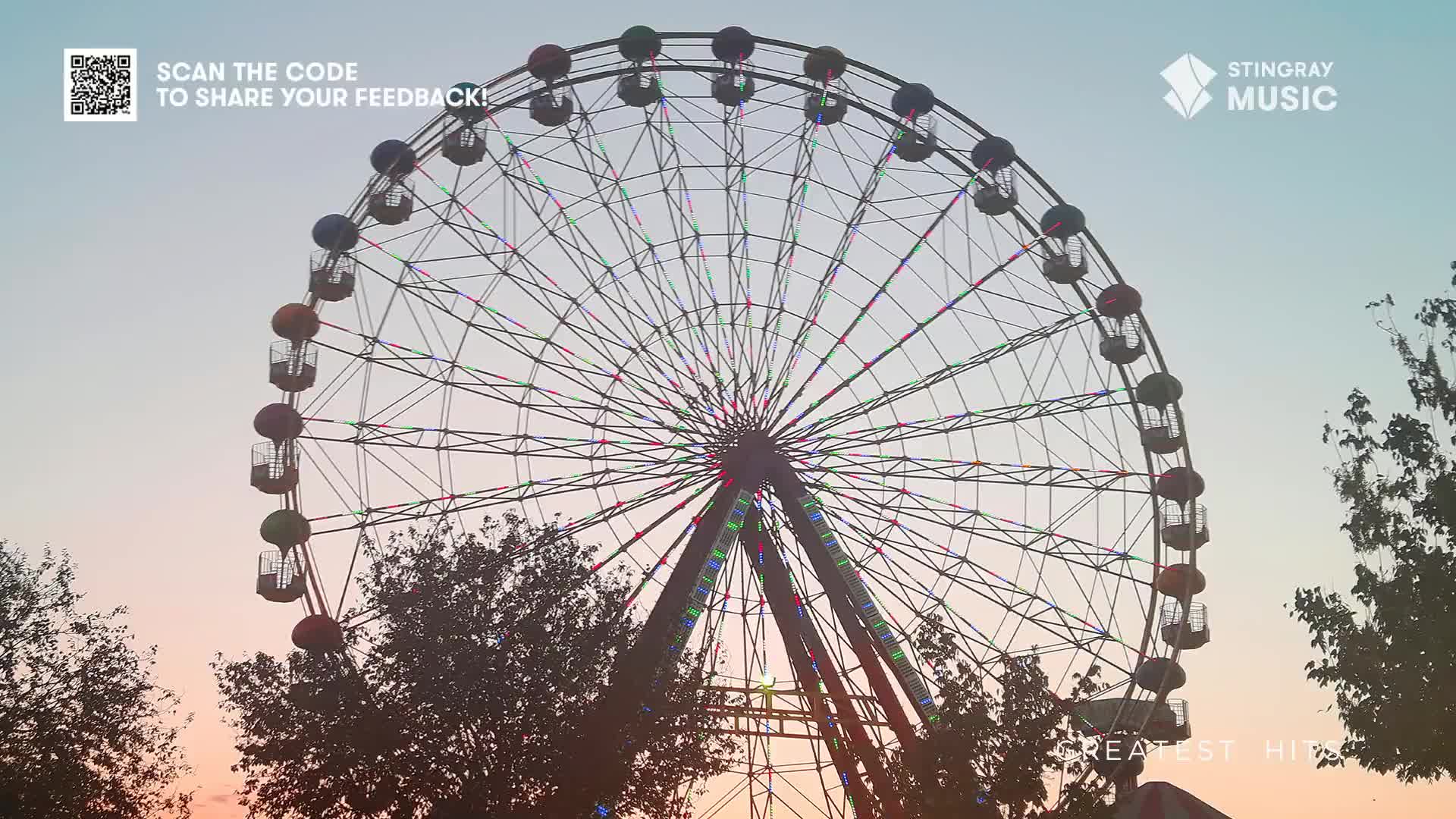 The Ferris wheel's colorful cars are silhouetted against a fading sky.  The whole scene feels calm, like a perfect backdrop for the Stingray Holiday Hits playing on the radio.
