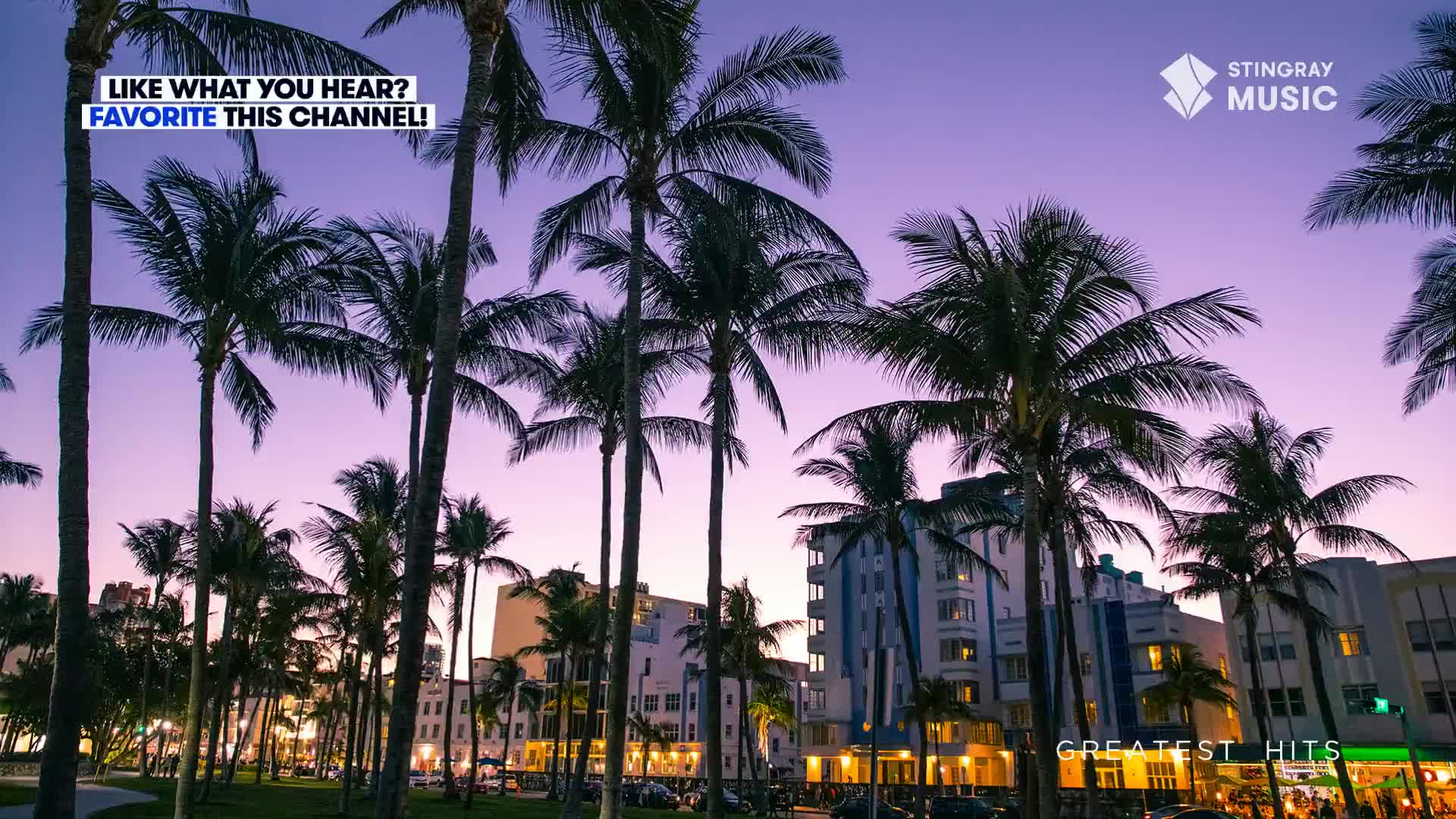Palm trees stand tall against a vibrant purple sky as the sun sets. The scene looks like it could be from a Stingray Holiday Hits playlist, maybe somewhere in Canada. 
