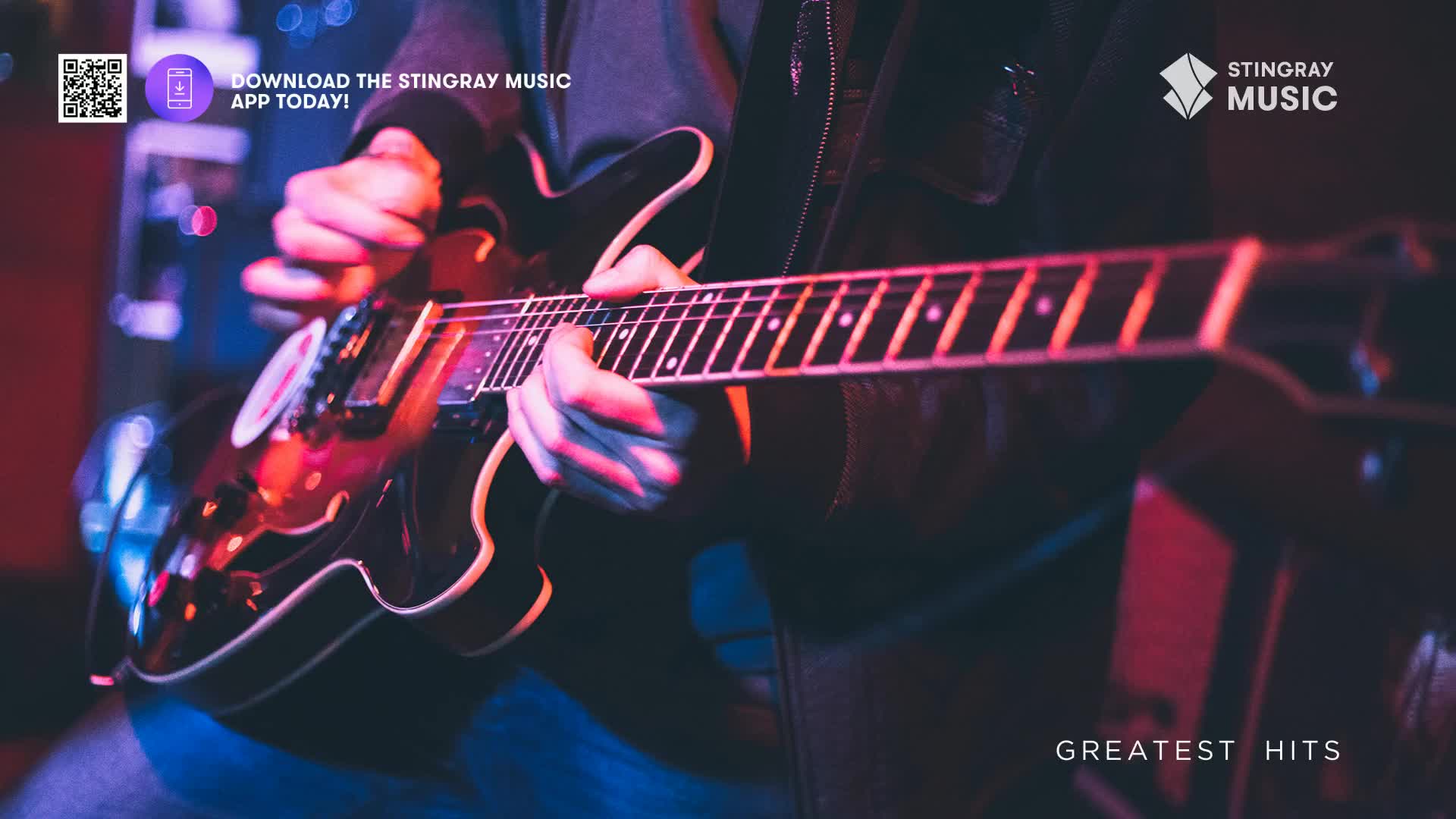 Fingers dance across the frets of a dark electric guitar, illuminated by a red stage light. The instrument's glossy body reflects the glow, as the music from Stingray Holiday Hits fills the air.
