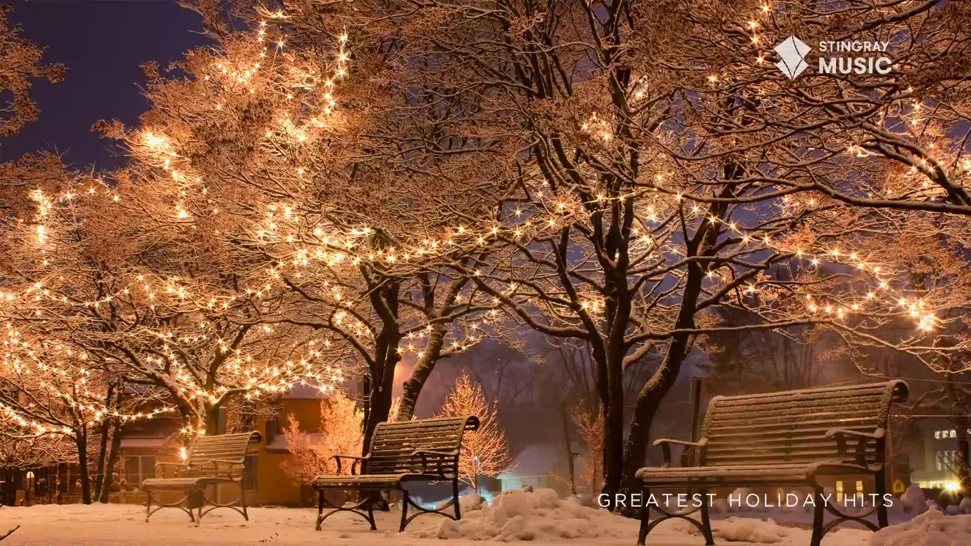 The trees are draped in strings of warm lights, illuminating the snow-covered park benches. It looks like the perfect scene for a Stingray Holiday Hits playlist, somewhere in Canada.
