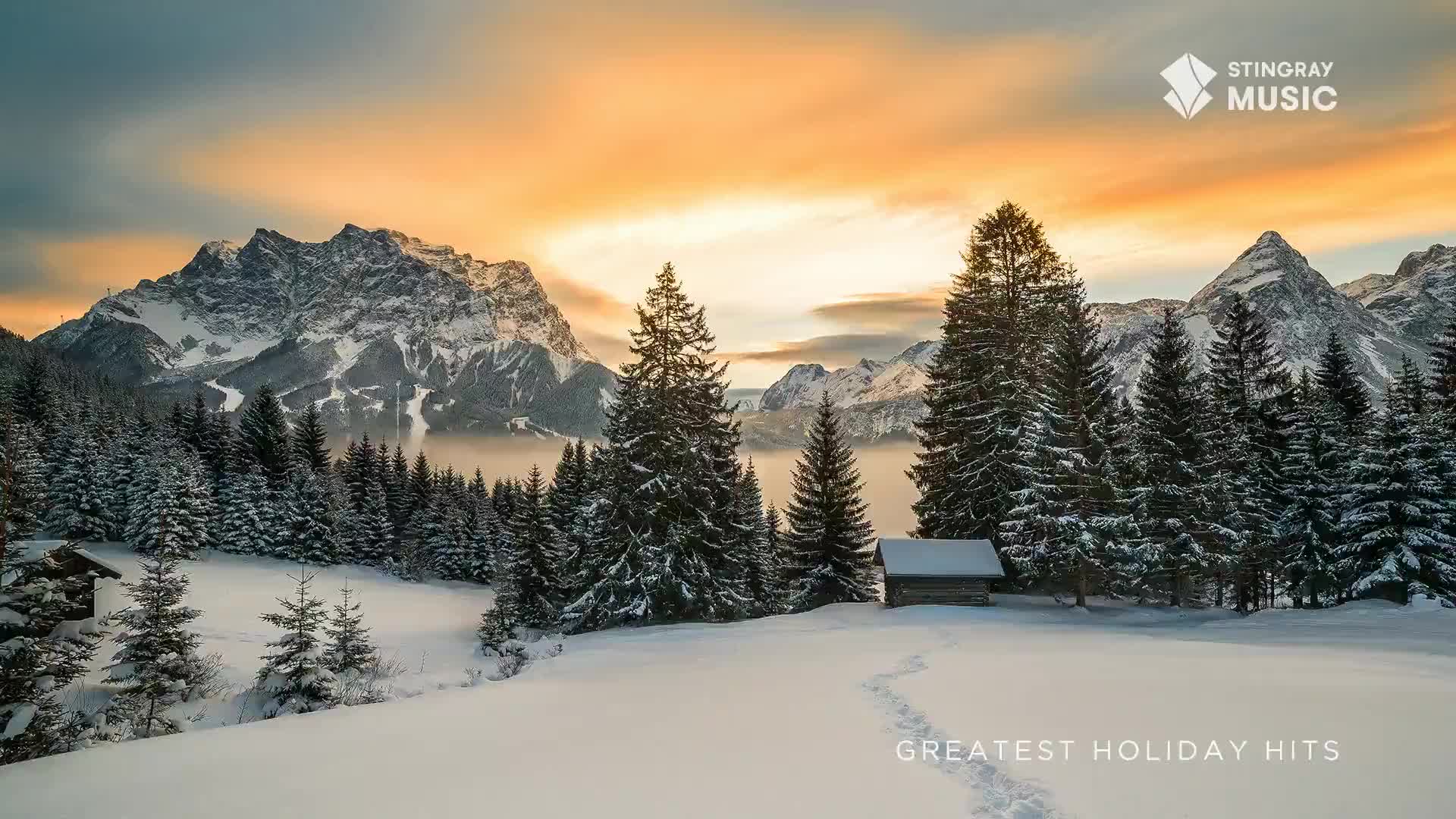 The snow-covered peaks of the Canadian Rockies are bathed in the warm glow of the setting sun.  A path of footprints leads through the pristine snow, promising a cozy cabin and perhaps some Stingray Holiday Hits.

