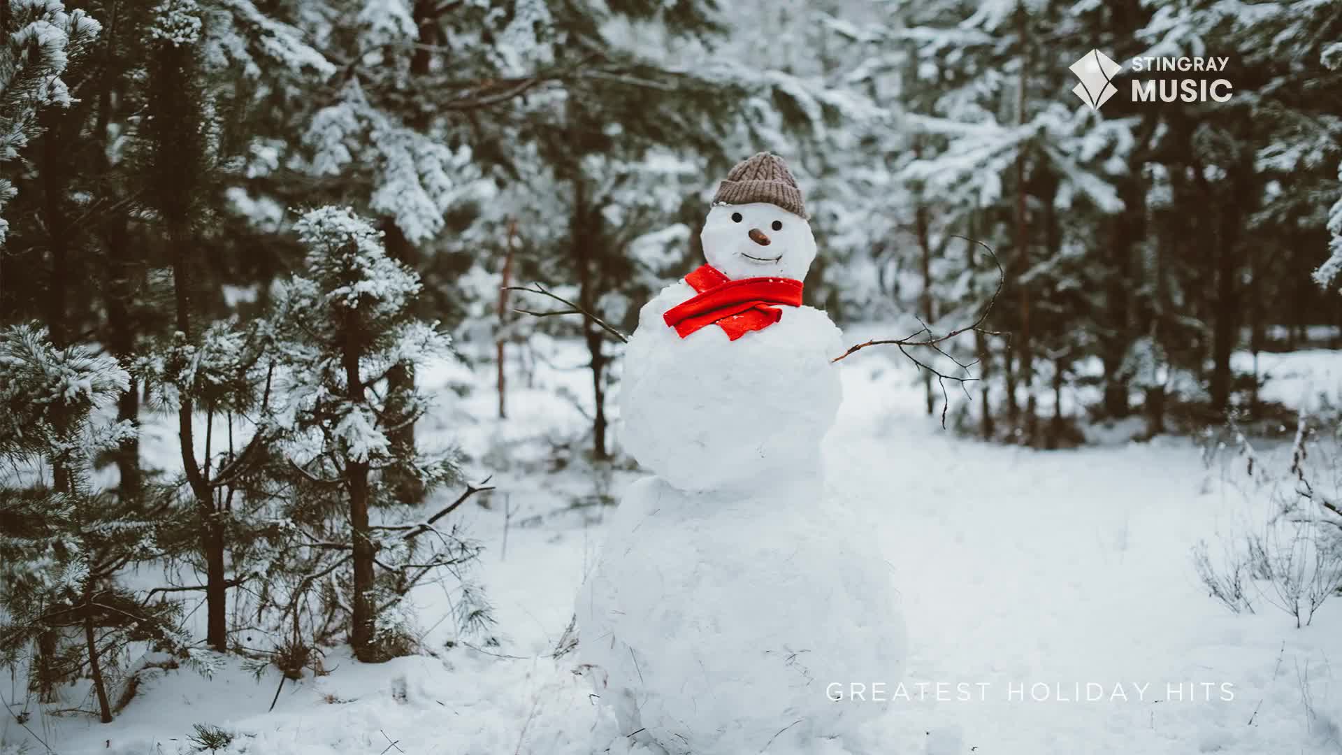 A cheerful snowman, complete with a scarf and hat, stands in a snowy forest. The scene evokes the feeling of a Stingray Holiday Hits playlist, perfectly capturing the spirit of a Canadian winter.
