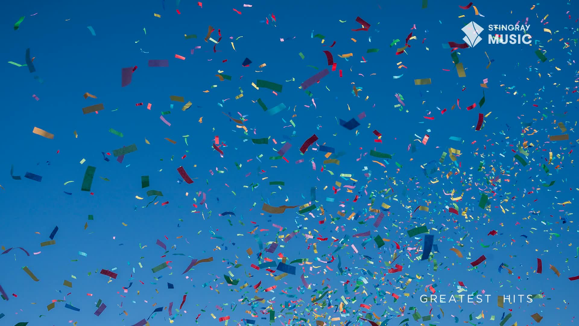 Confetti rains down against a brilliant blue sky, a vibrant cascade of red, gold, and green. It's a celebration, a moment of pure joy from Stingray Holiday Hits.