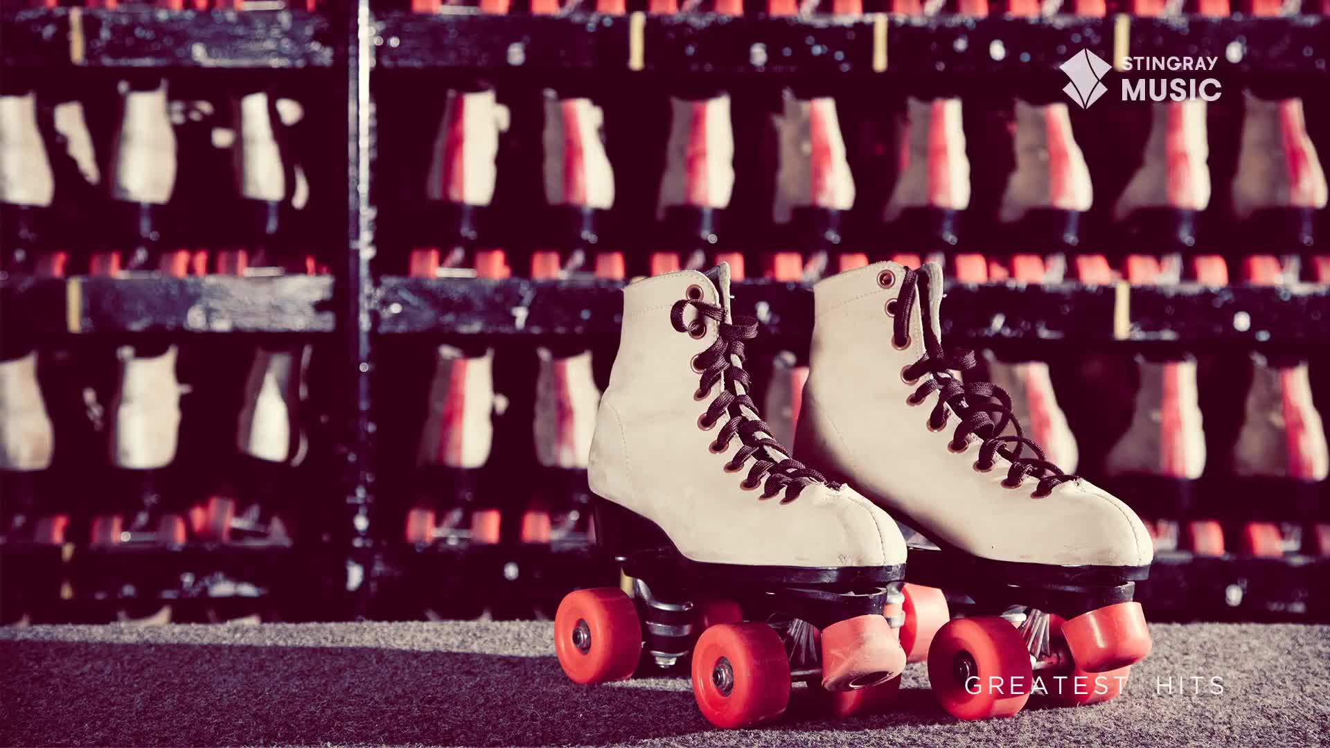 A pair of cream-colored roller skates with bright orange wheels sits ready on the carpeted floor. Behind them, rows of skates hang neatly in their racks, a familiar sight at any Canadian rink.