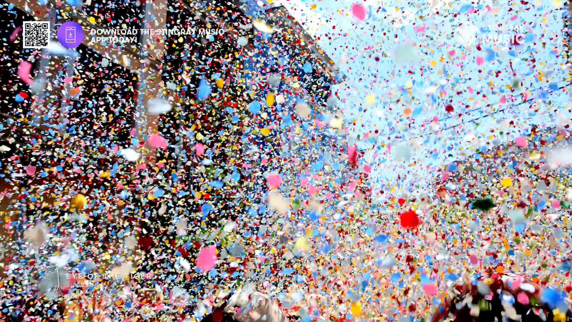 Confetti rains down in a vibrant cascade of red, blue, and yellow. It's a Canadian celebration, likely a holiday hit, with the air thick with paper pieces.
