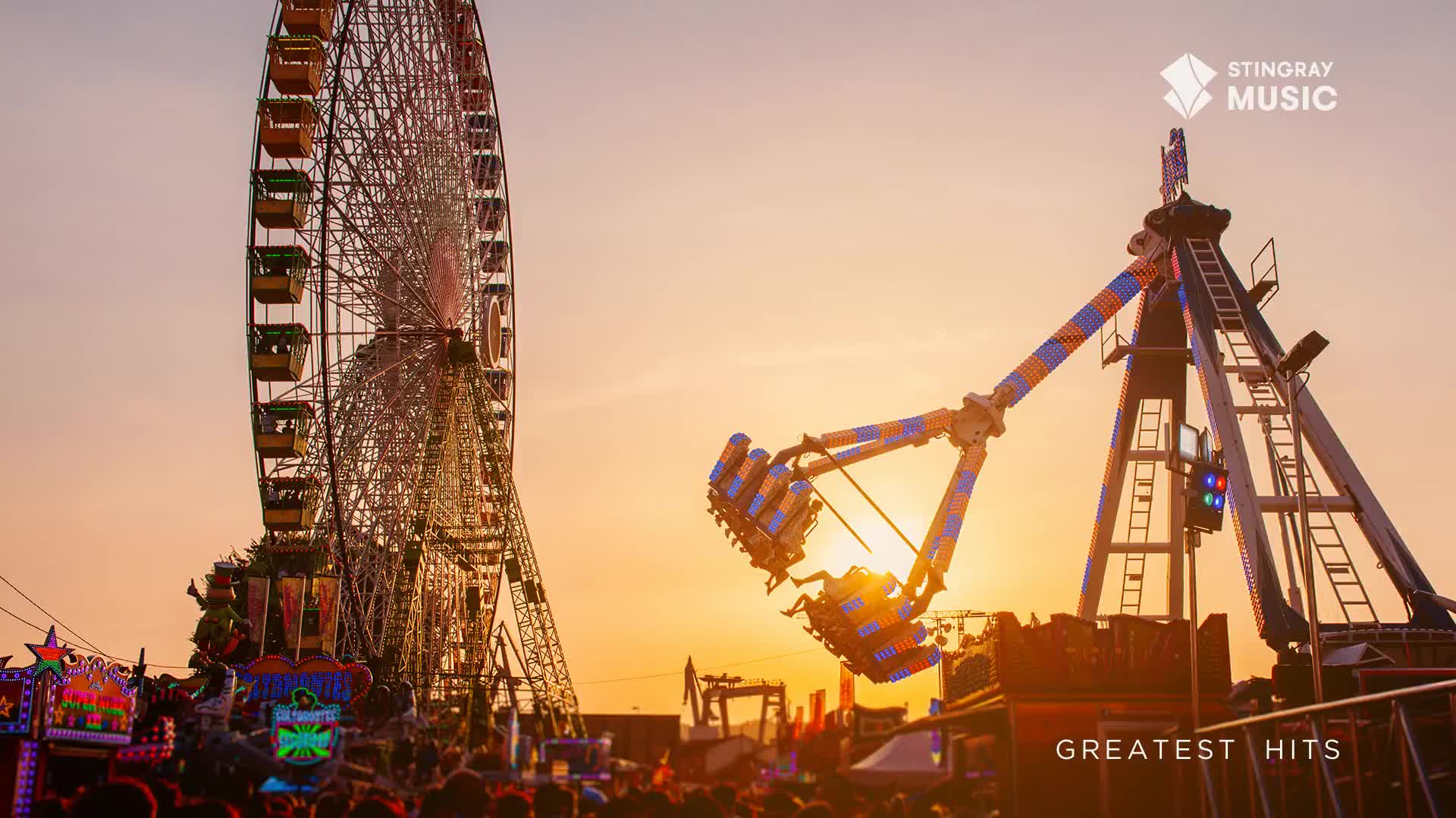 The pendulum ride swings riders high against the orange sky, while the Ferris wheel stands tall in the background. A crowd gathers below, enjoying the evening at this Canadian fair.
