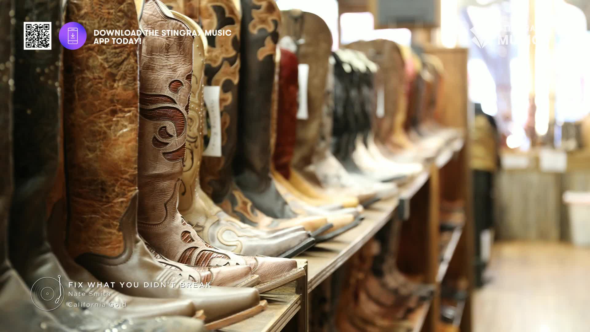 Boots of various styles and colors stand shoulder-to-shoulder on a wooden shelf. The Stingray Hot Country logo and a song title are visible at the bottom, hinting at a soundtrack for a boot-shopping spree.
Boots of various styles and colors stand shoulder-to-shoulder on a wooden shelf. The Stingray Hot Country logo and a song title are visible at the bottom, hinting at a soundtrack for a boot-shopping spree.