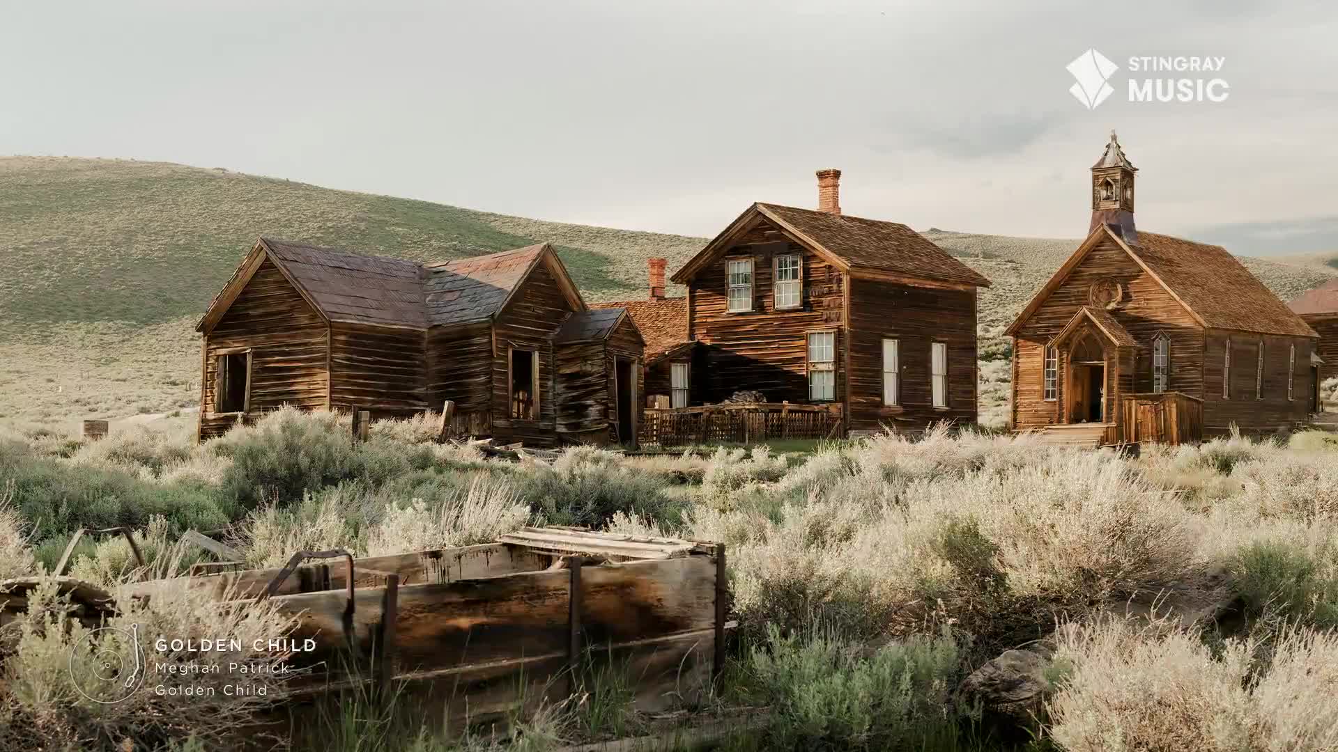 Weathered wooden buildings sit amidst overgrown brush under a hazy sky. The scene, reminiscent of an old Western town, is featured on Stingray Hot Country.
Weathered wooden buildings sit amidst overgrown brush under a hazy sky. The scene, reminiscent of an old Western town, is featured on Stingray Hot Country.