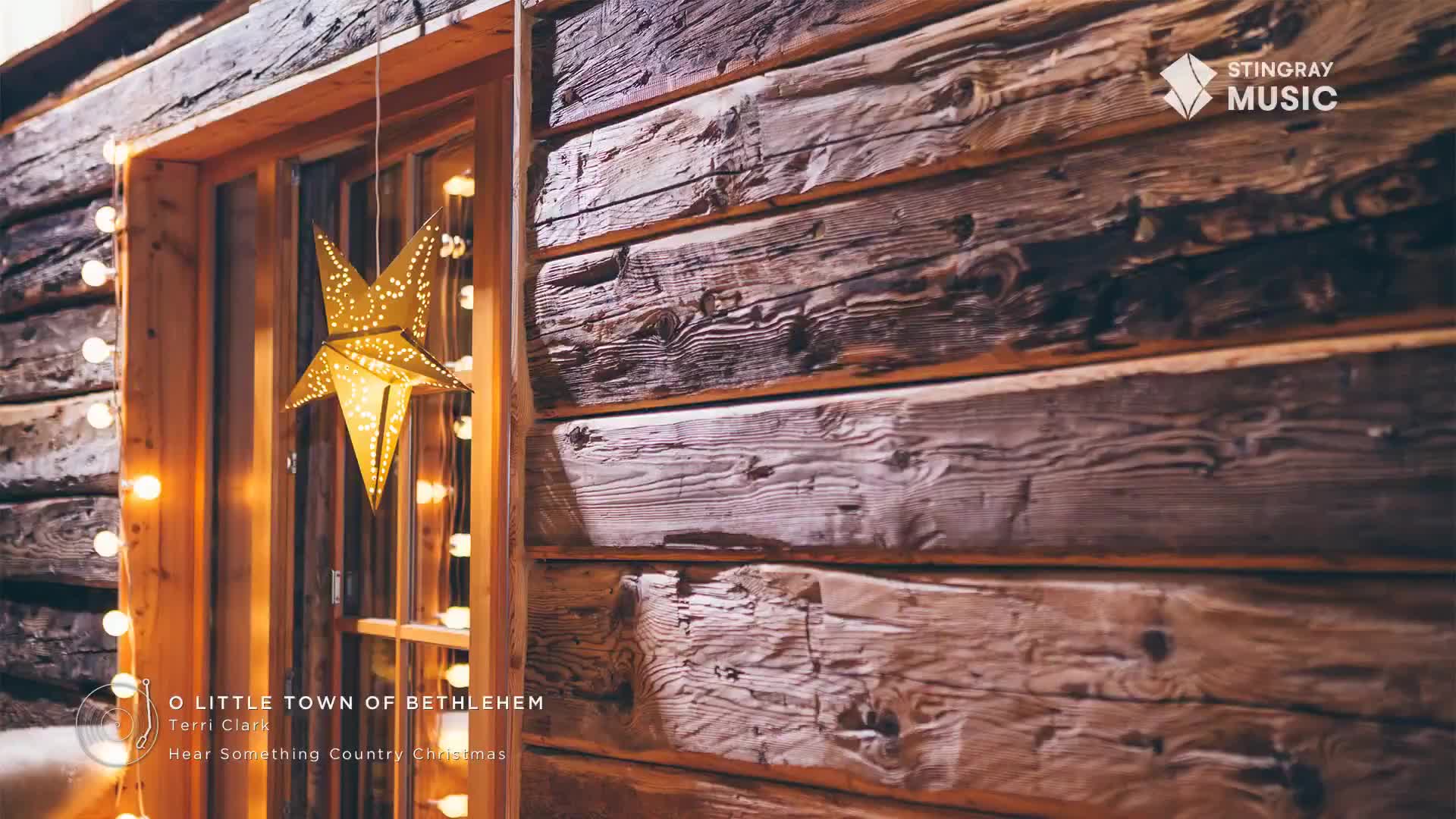 A string of warm lights frames a window, beside a weathered wooden wall. A golden star, pierced with tiny holes, hangs in the window, catching the glow.
A string of warm lights frames a window, beside a weathered wooden wall. A golden star, pierced with tiny holes, hangs in the window, catching the glow.