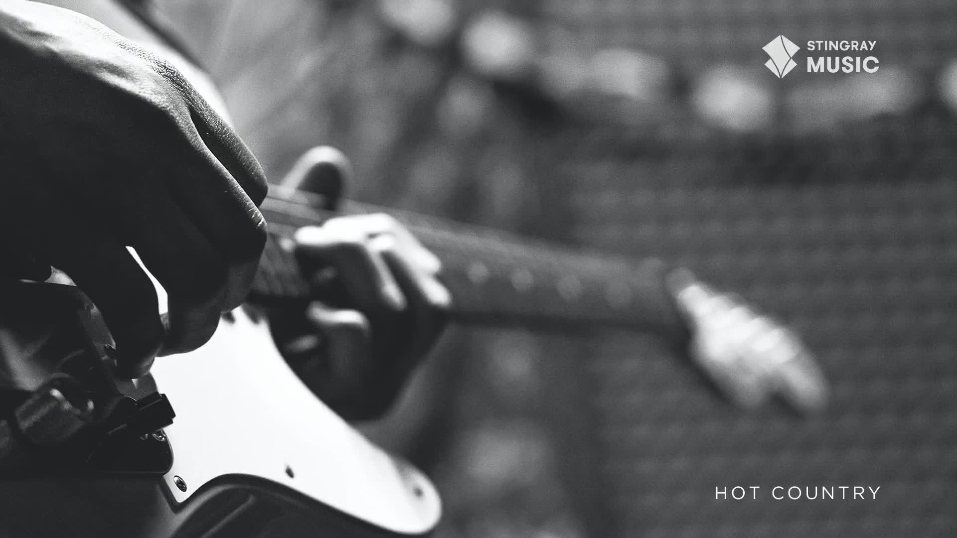 Fingers dance across the fretboard of a white electric guitar, the sound of hot country music filling the air. The player's hands move with practiced ease, shaping chords as the Stingray Music logo appears.