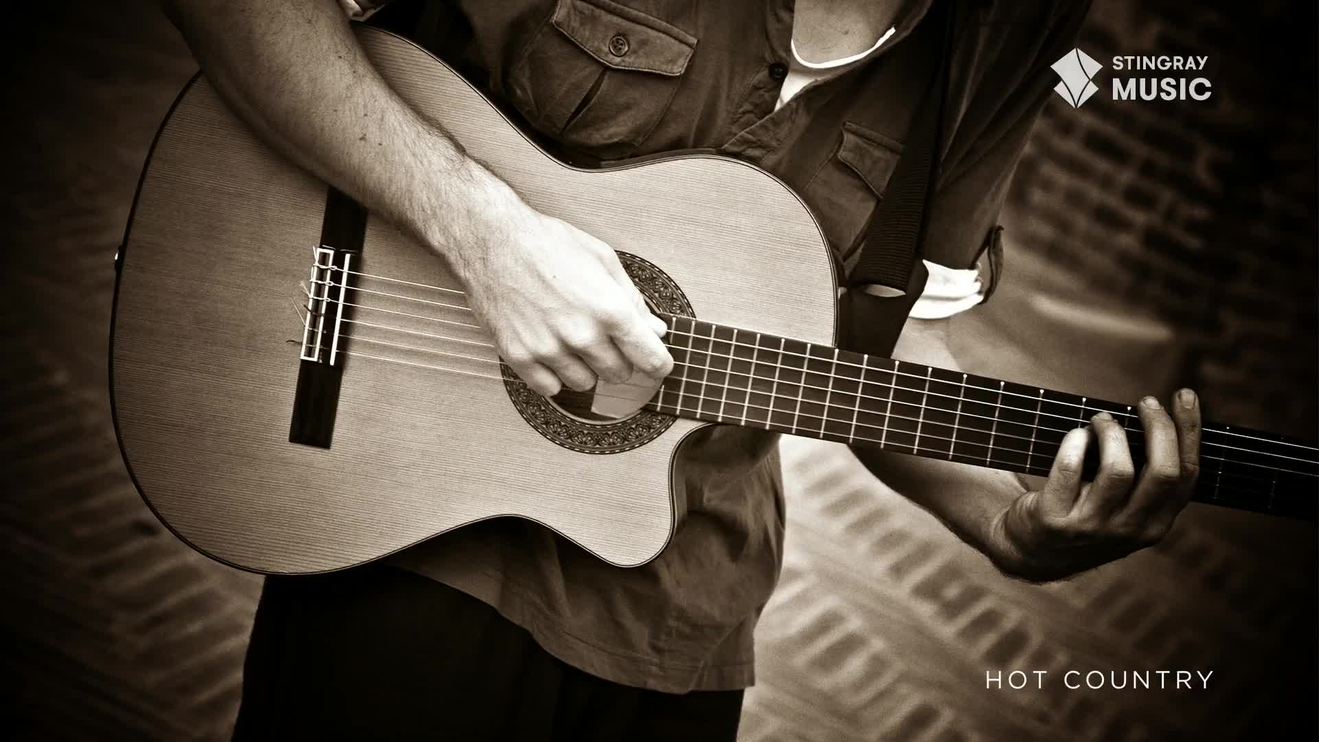 Fingers move across the fretboard of an acoustic guitar, strumming a chord. The warm tones of a Canadian country tune fill the air.