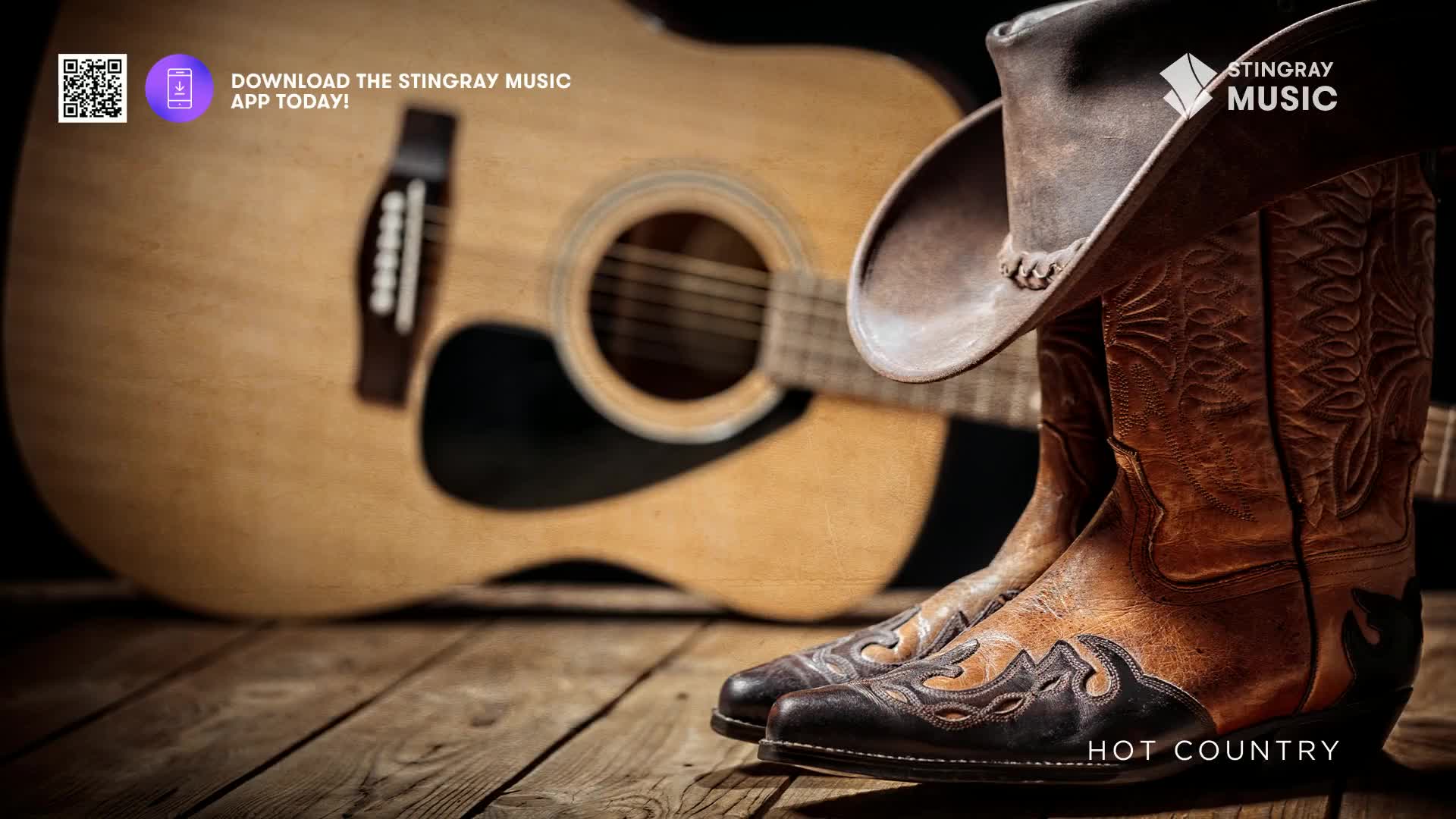 A worn cowboy hat rests atop a pair of intricately stitched leather boots, their tips pointing towards a classic acoustic guitar. The wood grain of the floorboards beneath them speaks of countless stories, much like the hot country music playing from Stingray.