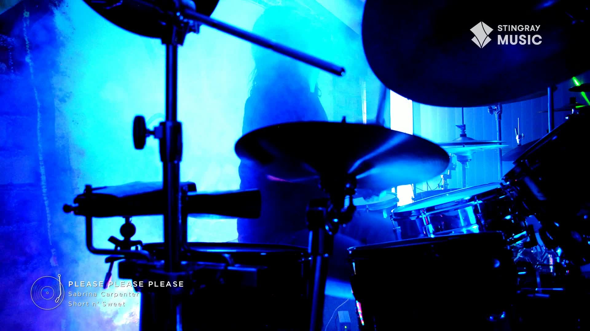 A drummer's silhouette is visible behind the kit, bathed in blue light. The Stingray Music logo is in the corner, and the song "Please Please Please" is playing.
