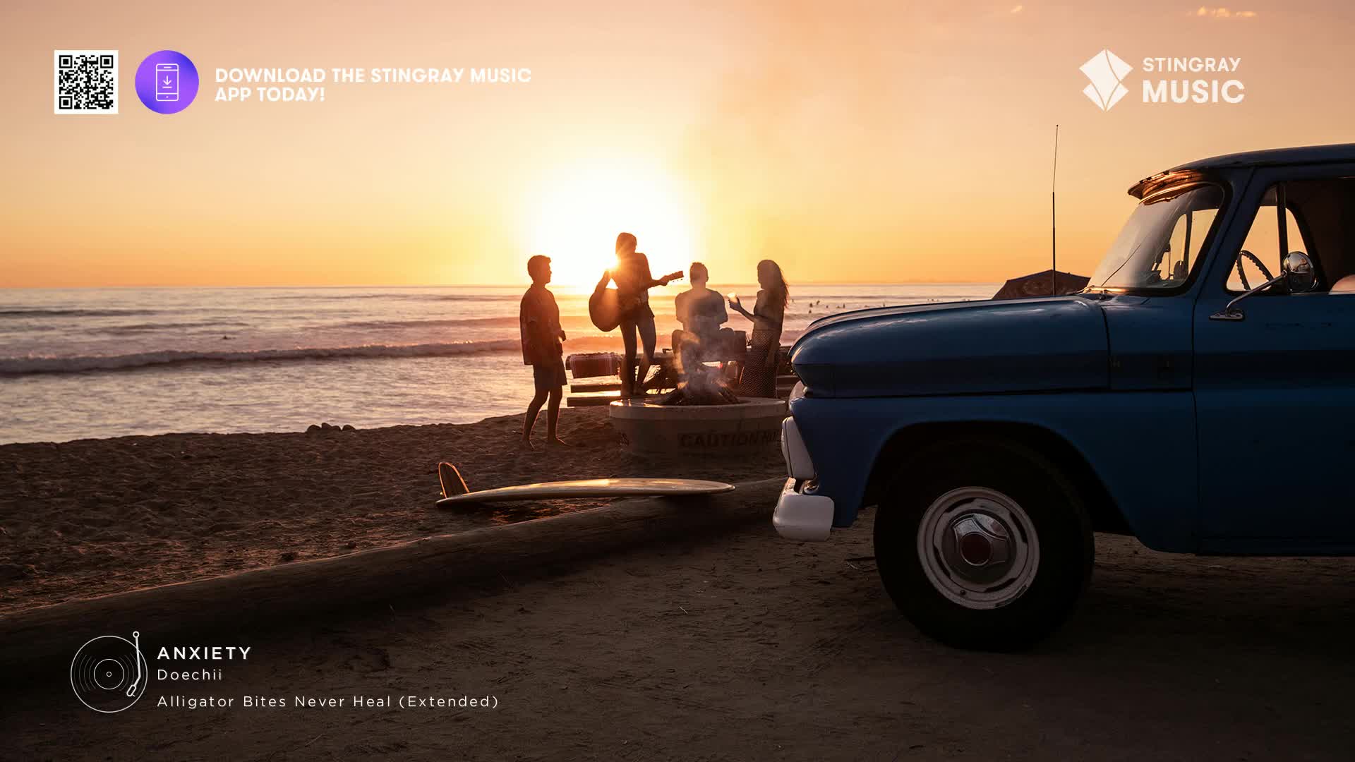 A group of friends are gathered around a small fire on the beach, silhouetted against the setting sun. A vintage blue truck sits parked nearby, its front end facing the ocean.
A group of friends are gathered around a small fire on the beach, silhouetted against the setting sun. A vintage blue truck sits parked nearby, its front end facing the ocean.