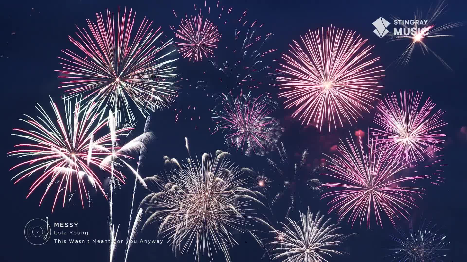 Pink and white fireworks burst open against a dark blue sky. The Stingray Music logo is in the corner, and a song title is listed below.
Pink and white fireworks burst open against a dark blue sky. The Stingray Music logo is in the corner, and a song title is listed below.