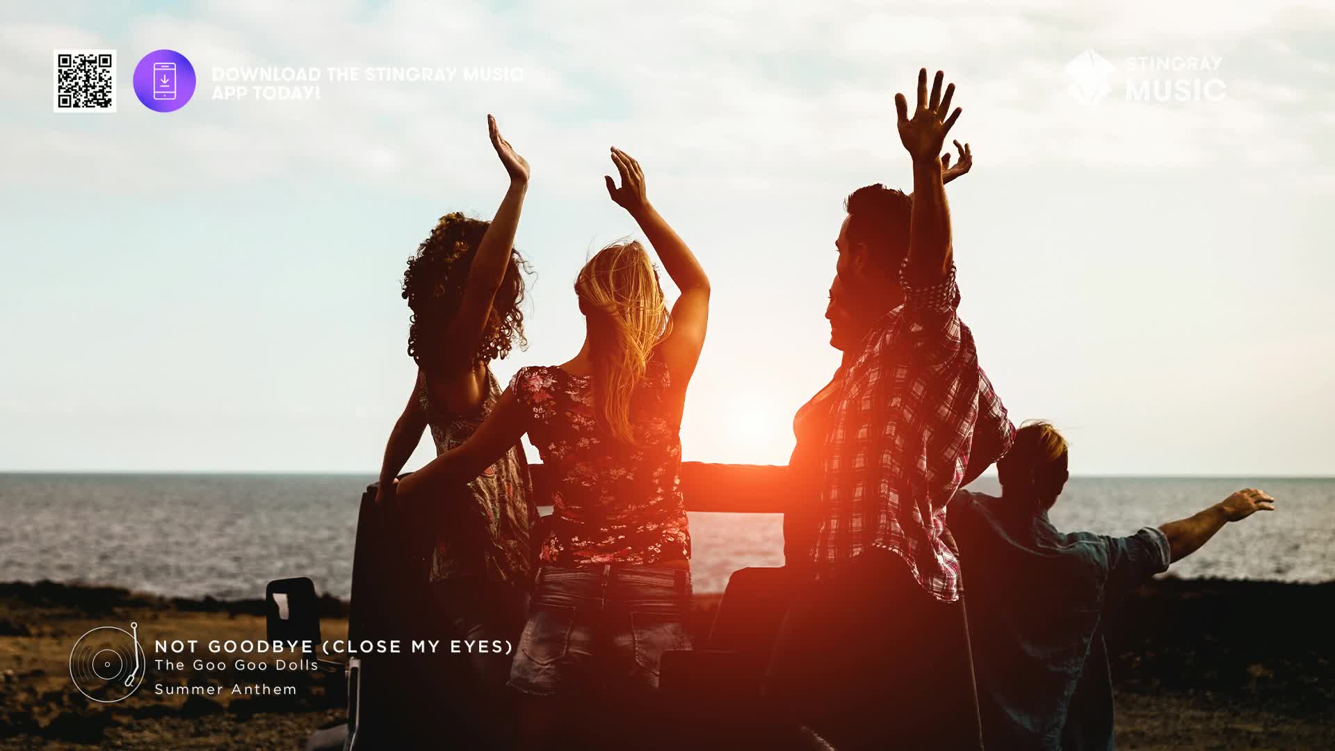 Four friends are raising their arms in celebration, silhouetted against the setting sun over the ocean. The warm glow of the sun catches their hair and clothes as they enjoy the moment.