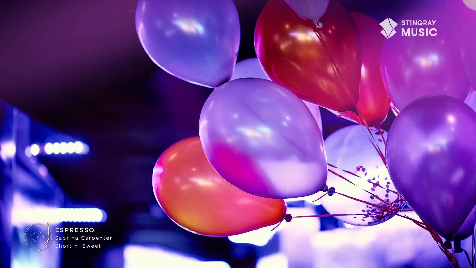 A cluster of balloons, some purple, some orange, and one with confetti, float against a dark background. The Stingray Music logo is visible in the upper right corner.