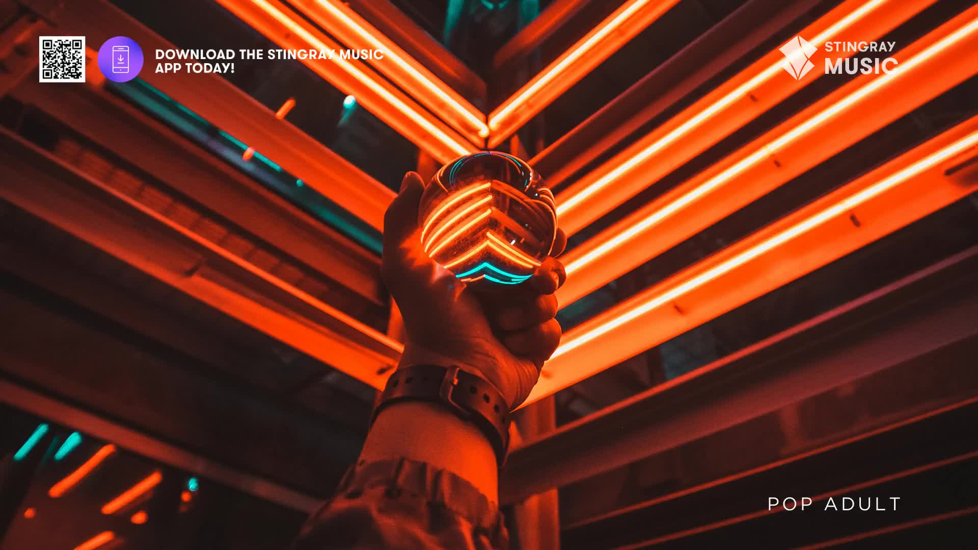 A hand holds a glass orb, reflecting the vibrant orange and teal neon lights of a Canadian venue. The orb catches the light, its surface showing a distorted, glowing chevron pattern.