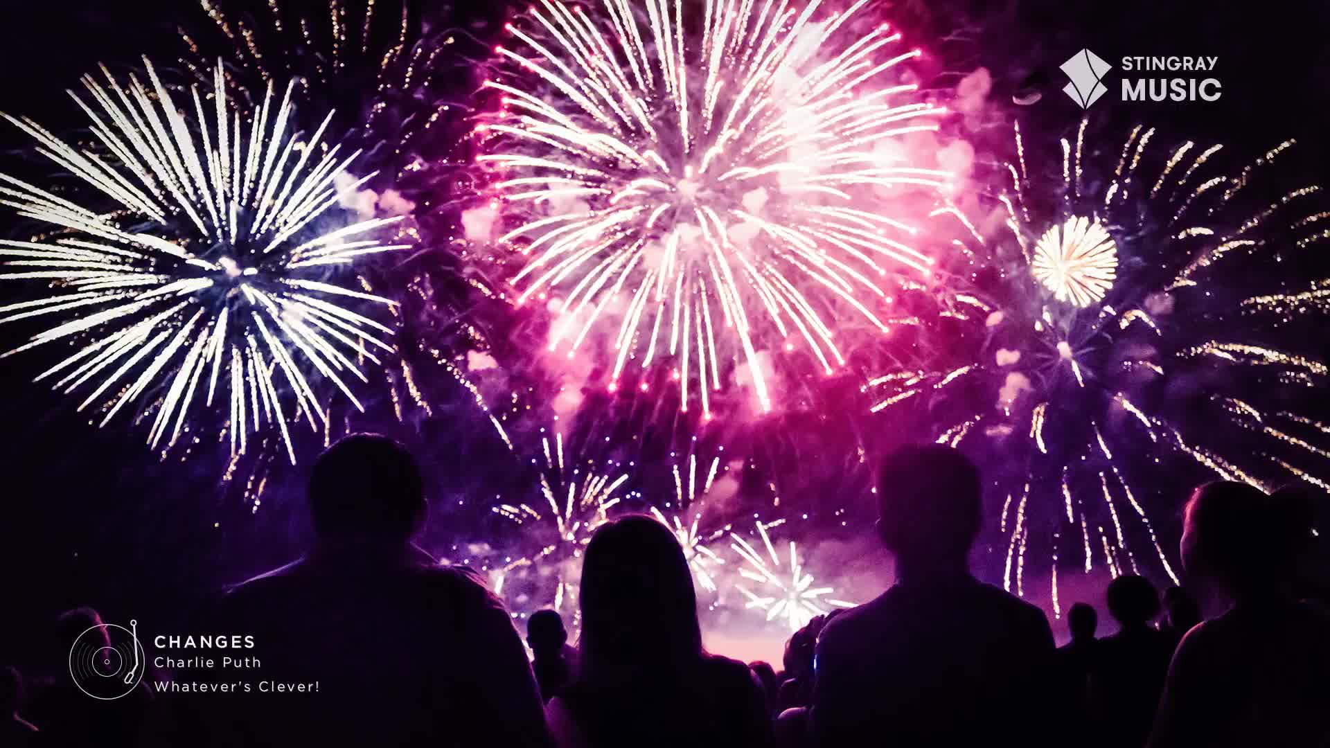 The sky above Canada bursts with vibrant pink and white fireworks, illuminating the silhouettes of people gathered below. A Stingray Music logo appears in the corner, hinting at a celebration soundtracked by Charlie Puth's "Changes."