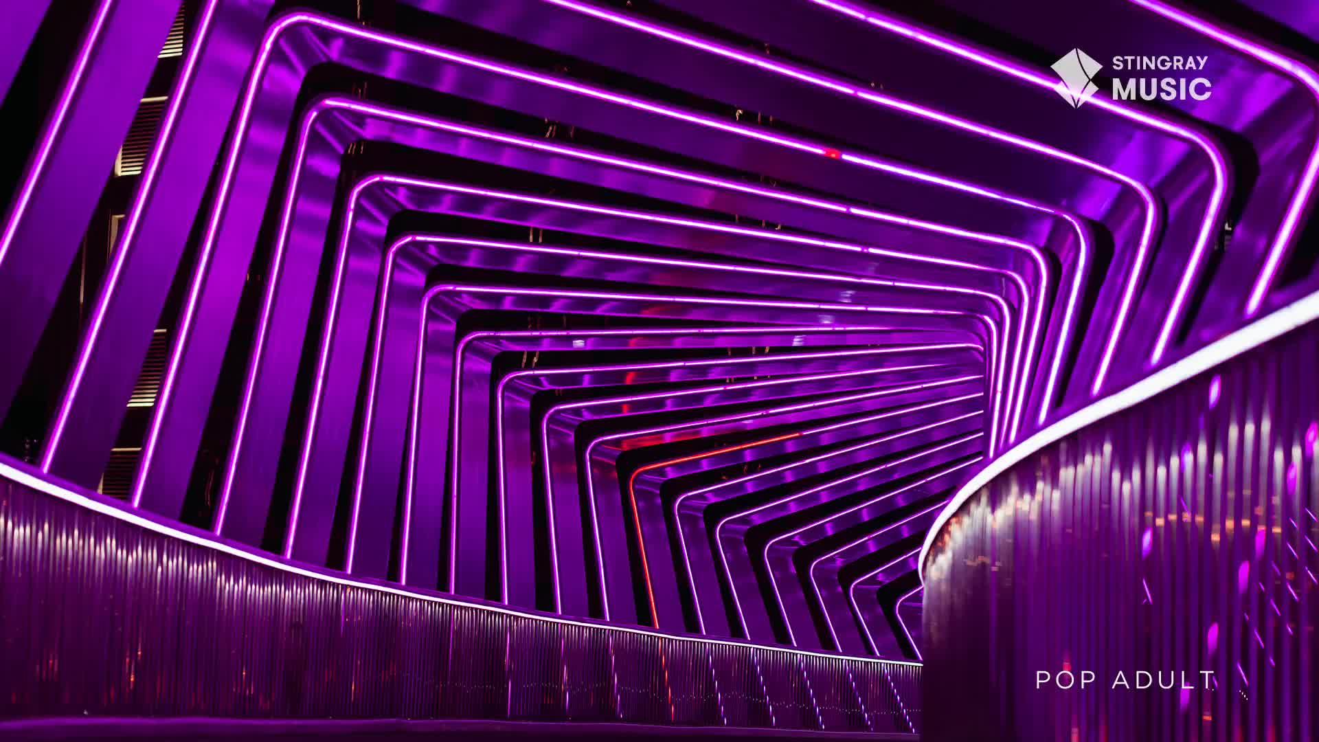 The tunnel ahead glows with a vibrant purple light, its metallic surfaces reflecting the neon tubes. This is the kind of modern art installation you'd expect to find in a Canadian city, a perfect backdrop for a Stingray Music pop adult broadcast.