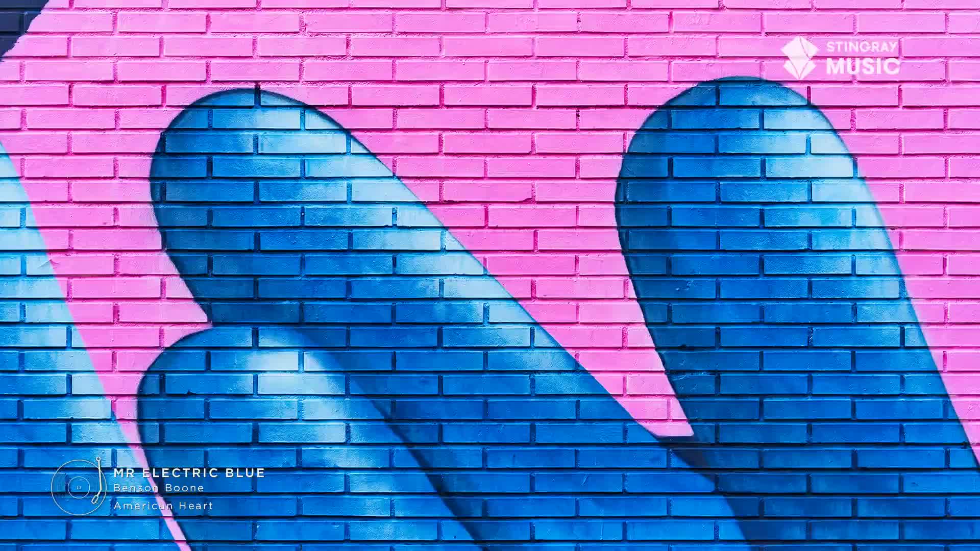 The bright pink brick wall is covered in bold blue shapes that look like elongated teardrops. A Stingray Music logo sits in the upper right corner.