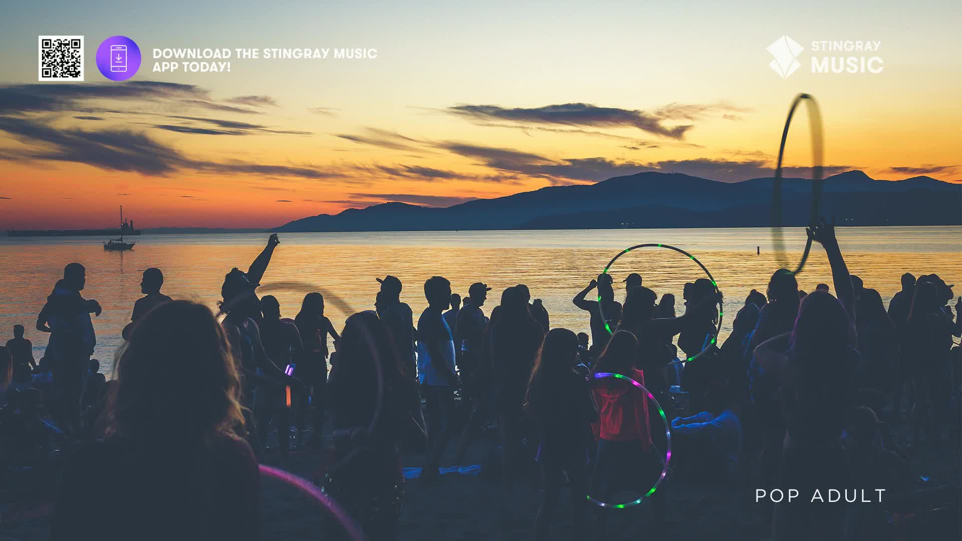 The sun dips below the mountains, painting the sky in hues of orange and purple as a crowd gathers on the beach. People are twirling illuminated hula hoops, their lights creating a vibrant spectacle against the darkening twilight. The sun dips below the mountains, painting the sky in hues of orange and purple as a crowd gathers on the beach. People are twirling illuminated hula hoops, their lights creating a vibrant spectacle against the darkening twilight.