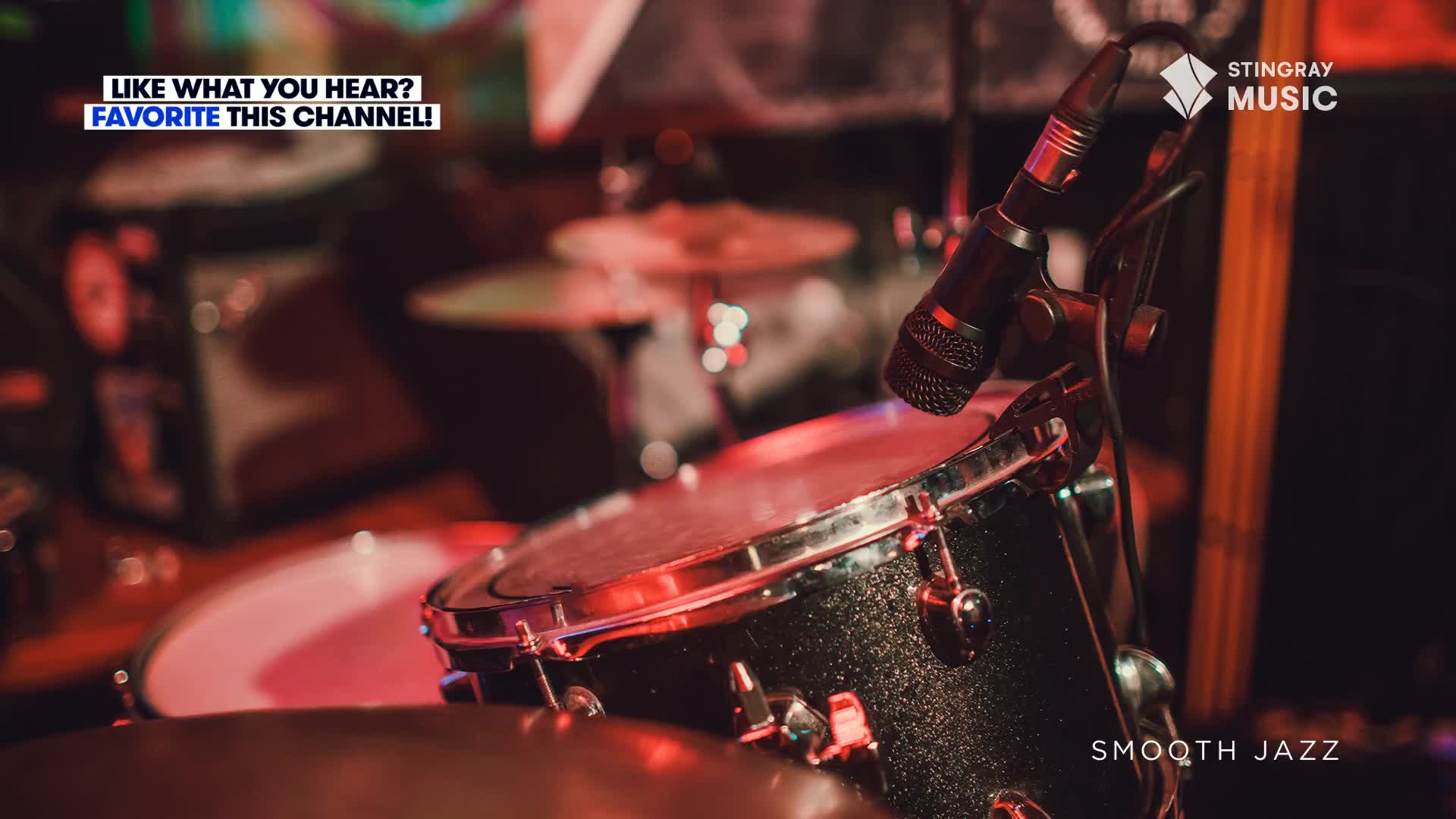 A microphone is poised over a drum, ready to capture the music. The scene, bathed in a warm red glow, hints at a live performance of Stingray Smooth Jazz.
