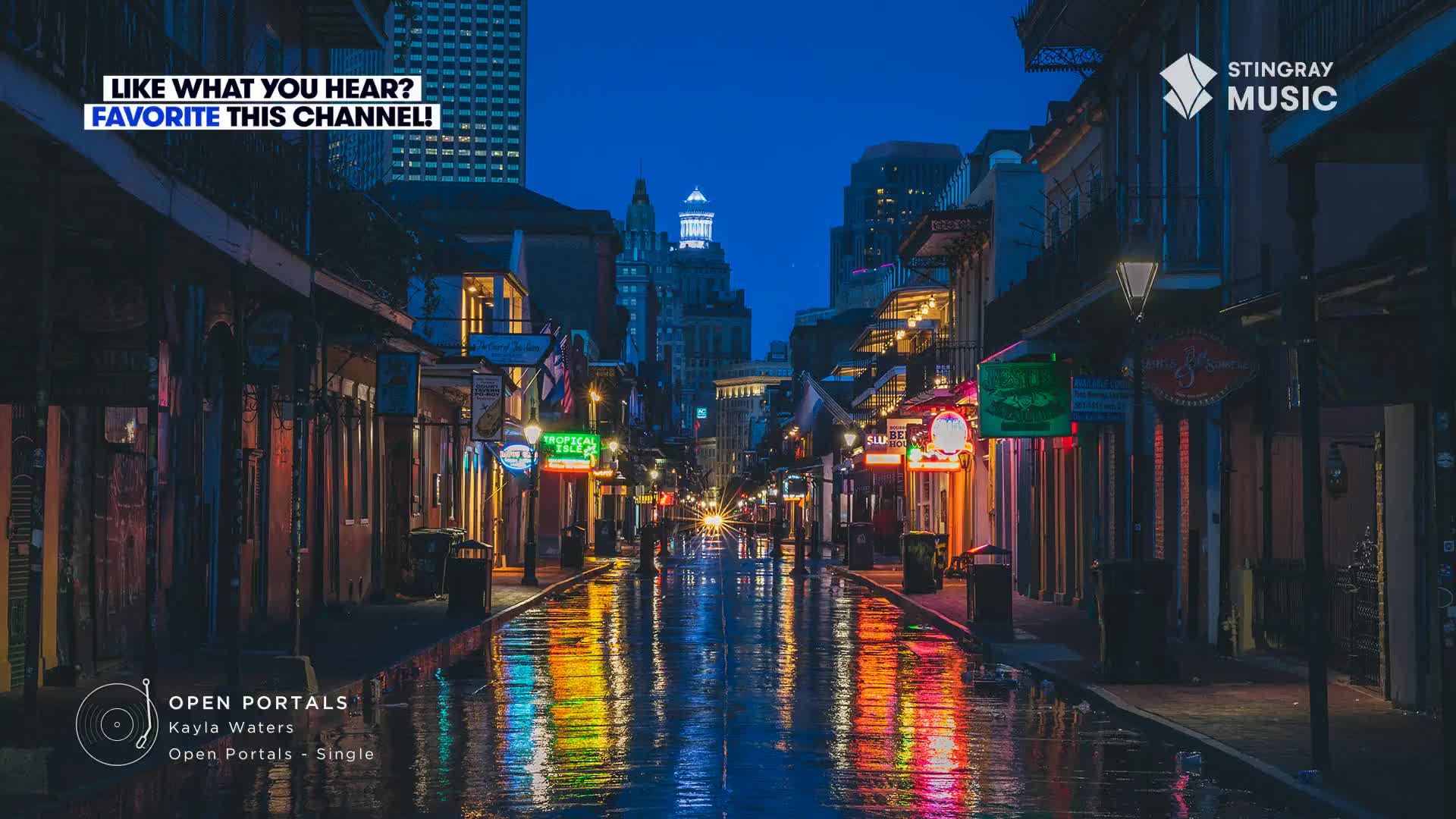 The street glistens with reflections of neon signs and lights from the buildings. A few figures walk down the wet pavement, while the music from Stingray Smooth Jazz plays softly in the background.
