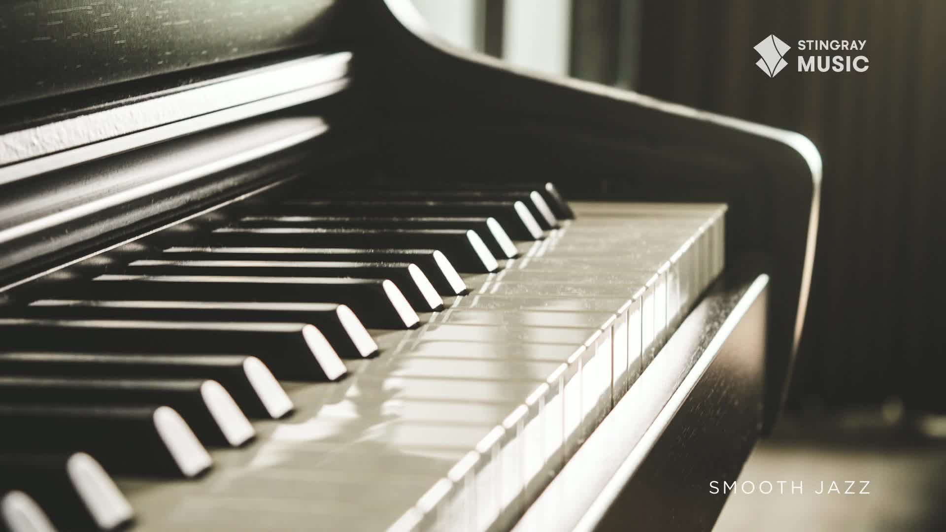 The keys of a grand piano gleam, reflecting the light as it hits the ebony and ivory. The Stingray Smooth Jazz logo, a Canadian favourite, sits in the corner.
