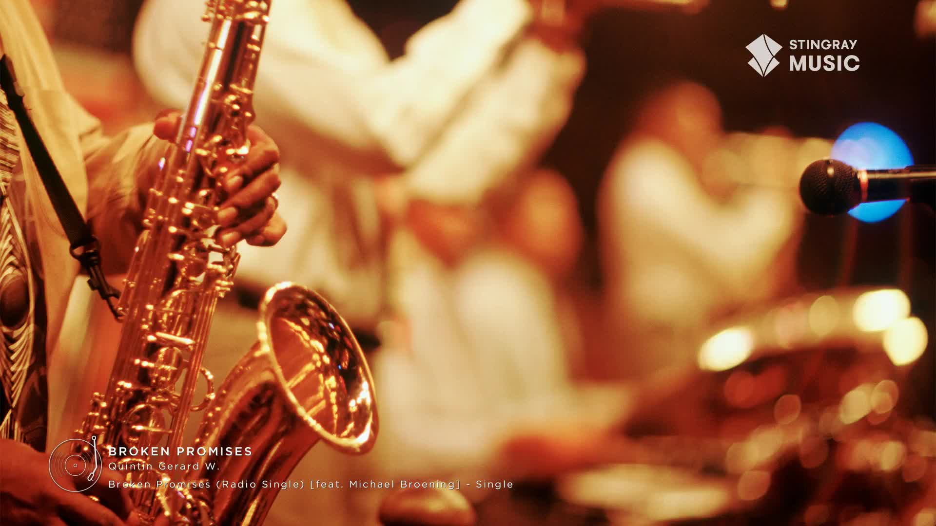 A musician's hand grips a saxophone, its golden finish reflecting the stage lights.  Behind him, other band members are blurred, contributing to the smooth jazz sound of a Stingray Music performance.
