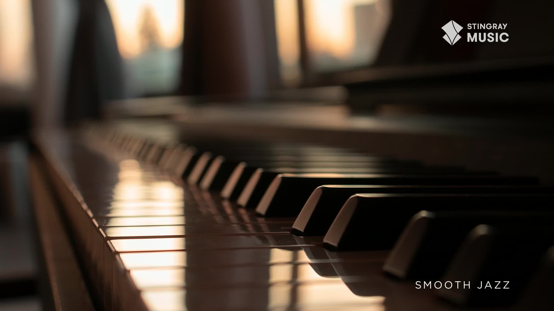 The sun's golden light reflects off the polished black and white keys of a grand piano. A subtle "Stingray Music" logo appears in the upper right corner, hinting at the smooth jazz playing.