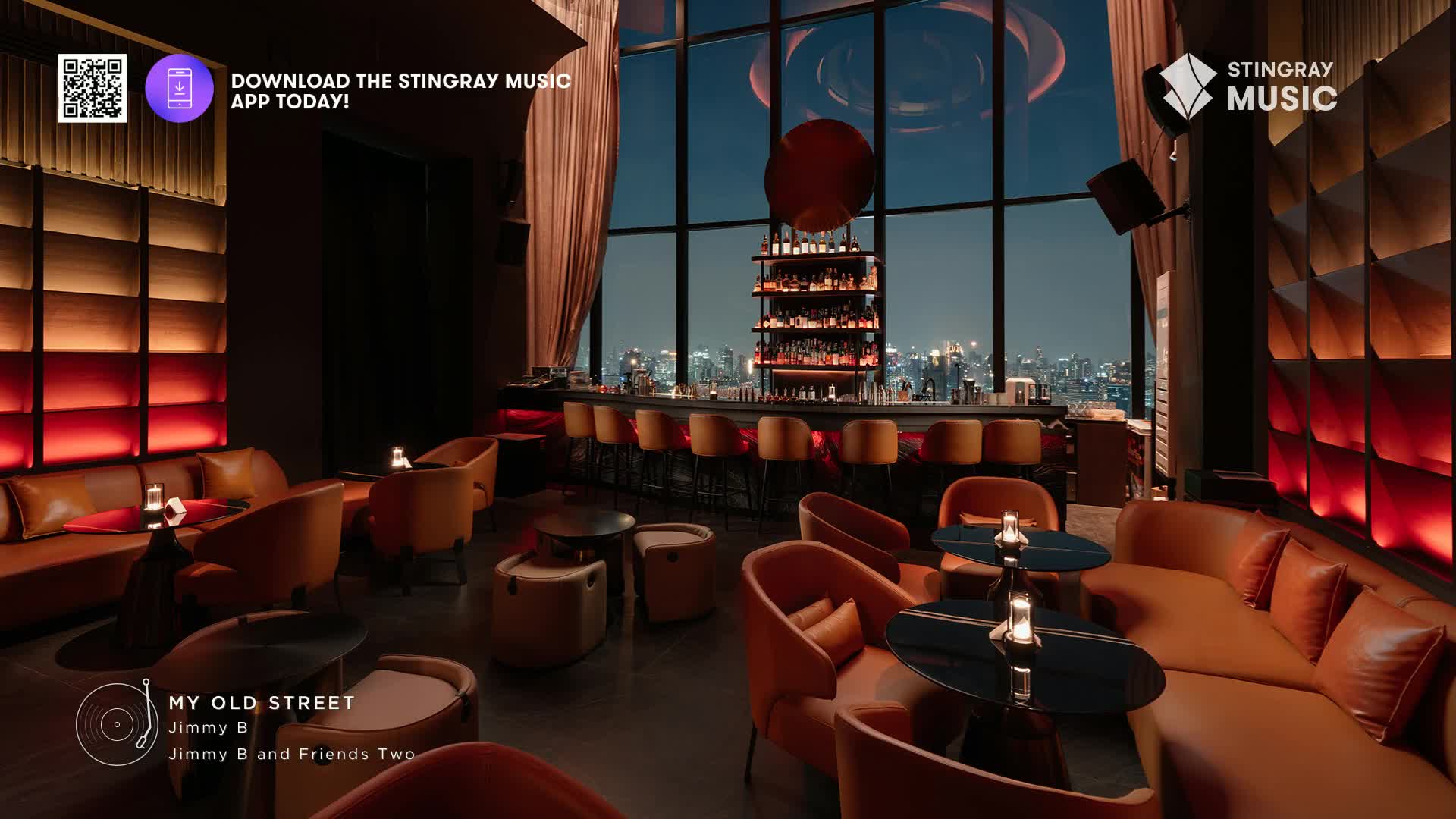 The smooth jazz from Stingray Music fills this upscale lounge, a perfect backdrop for the city lights twinkling outside. Plush orange seating invites guests to relax as the evening unfolds.