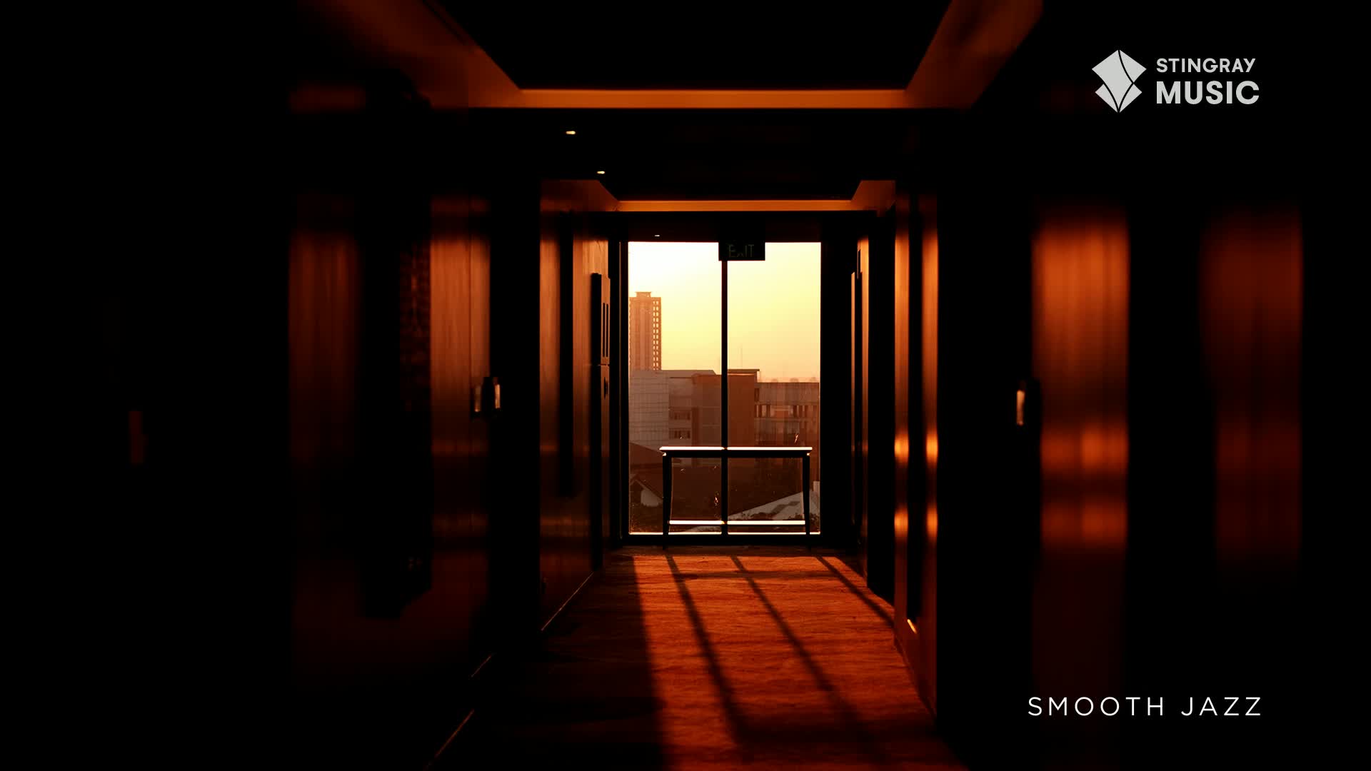 The sun sets over a Canadian city, casting long shadows down a hotel hallway. Smooth jazz plays softly, a perfect soundtrack to the warm, golden light.