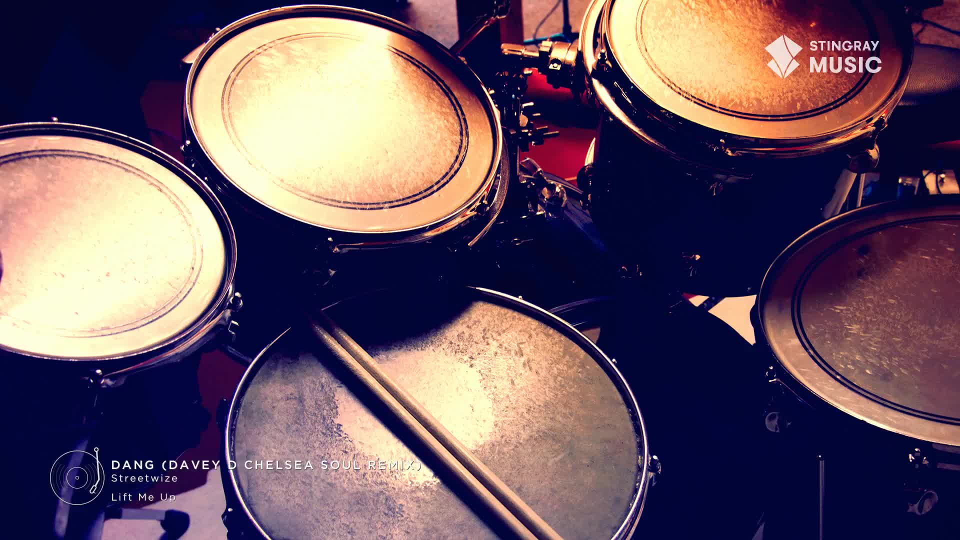 Drumsticks rest on a snare drum, ready for the beat. The Stingray Music logo hints at a smooth jazz track playing.