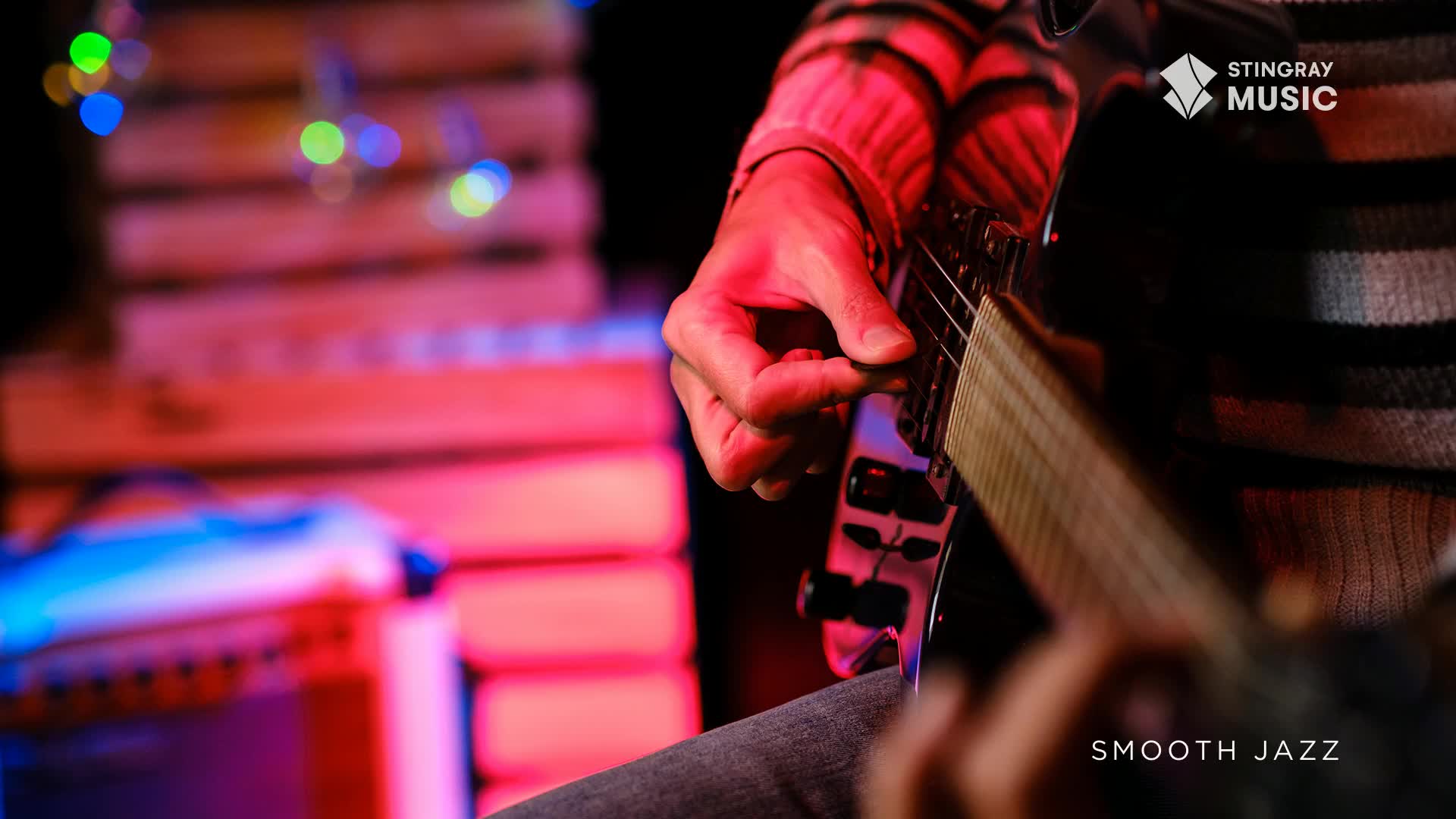 A hand strums an electric guitar, the pick catching the strings. The stage lights cast a warm glow over the scene, hinting at a smooth jazz performance in Canada. A hand strums an electric guitar, the pick catching the strings. The stage lights cast a warm glow over the scene, hinting at a smooth jazz performance in Canada.